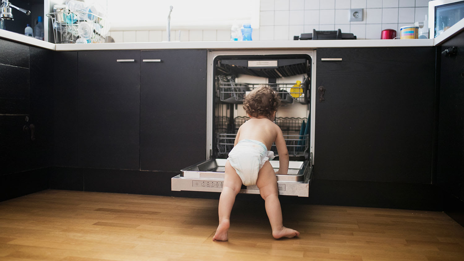 Baby looking inside dishwasher