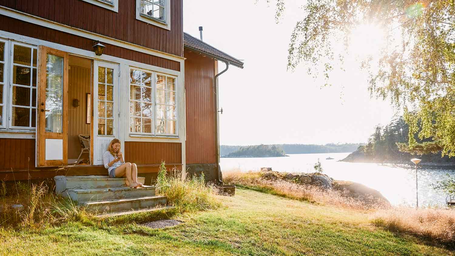 Woman sitting by the doorway at a lake house