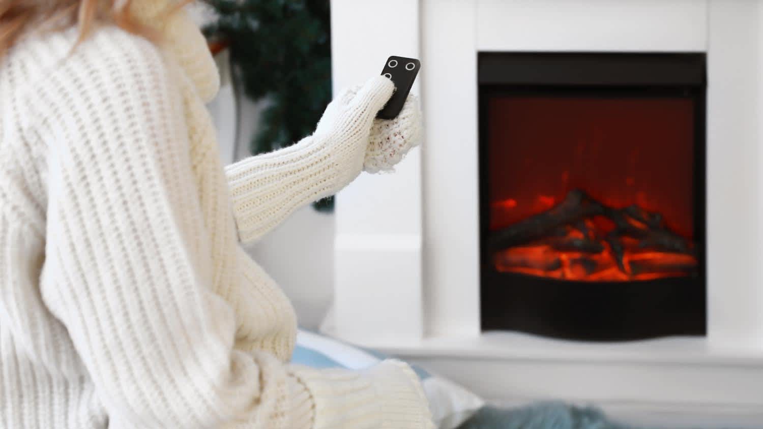 A woman sitting near electric fireplace