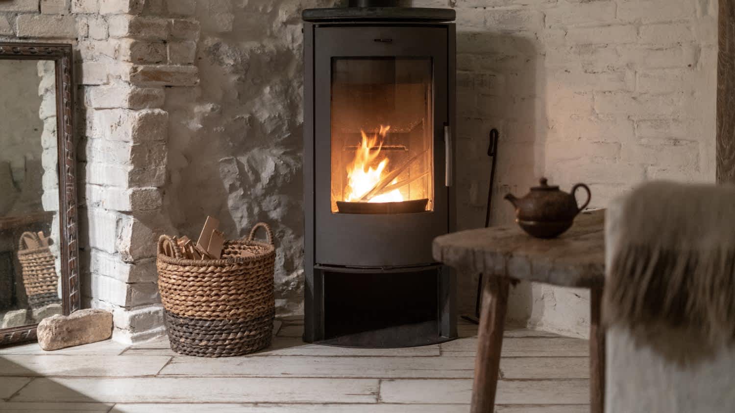 A fireplace with metal body and glass door