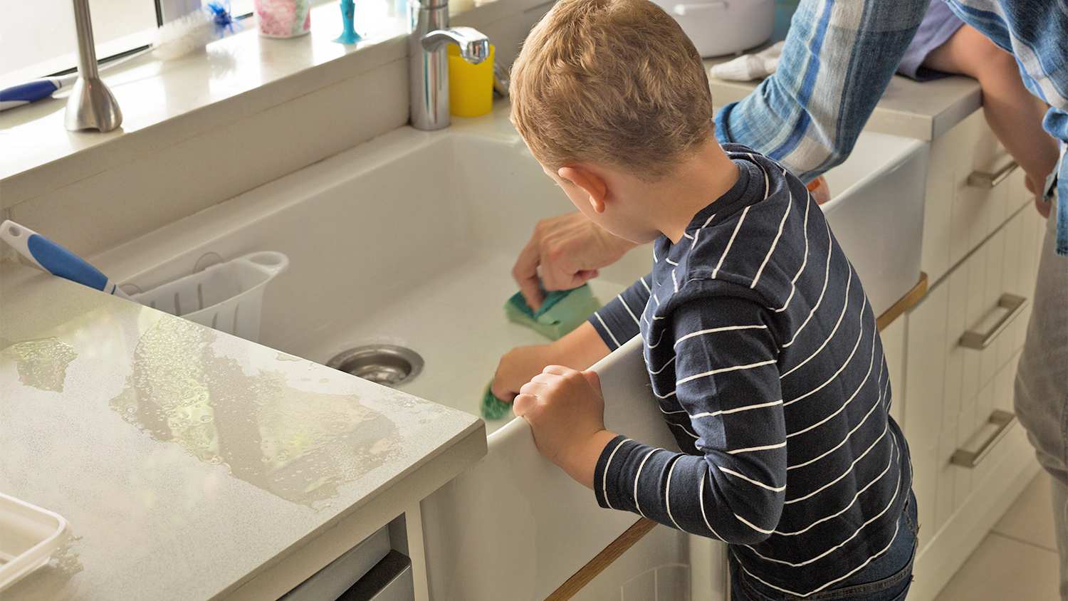 father and son cleaning the kitchen sink