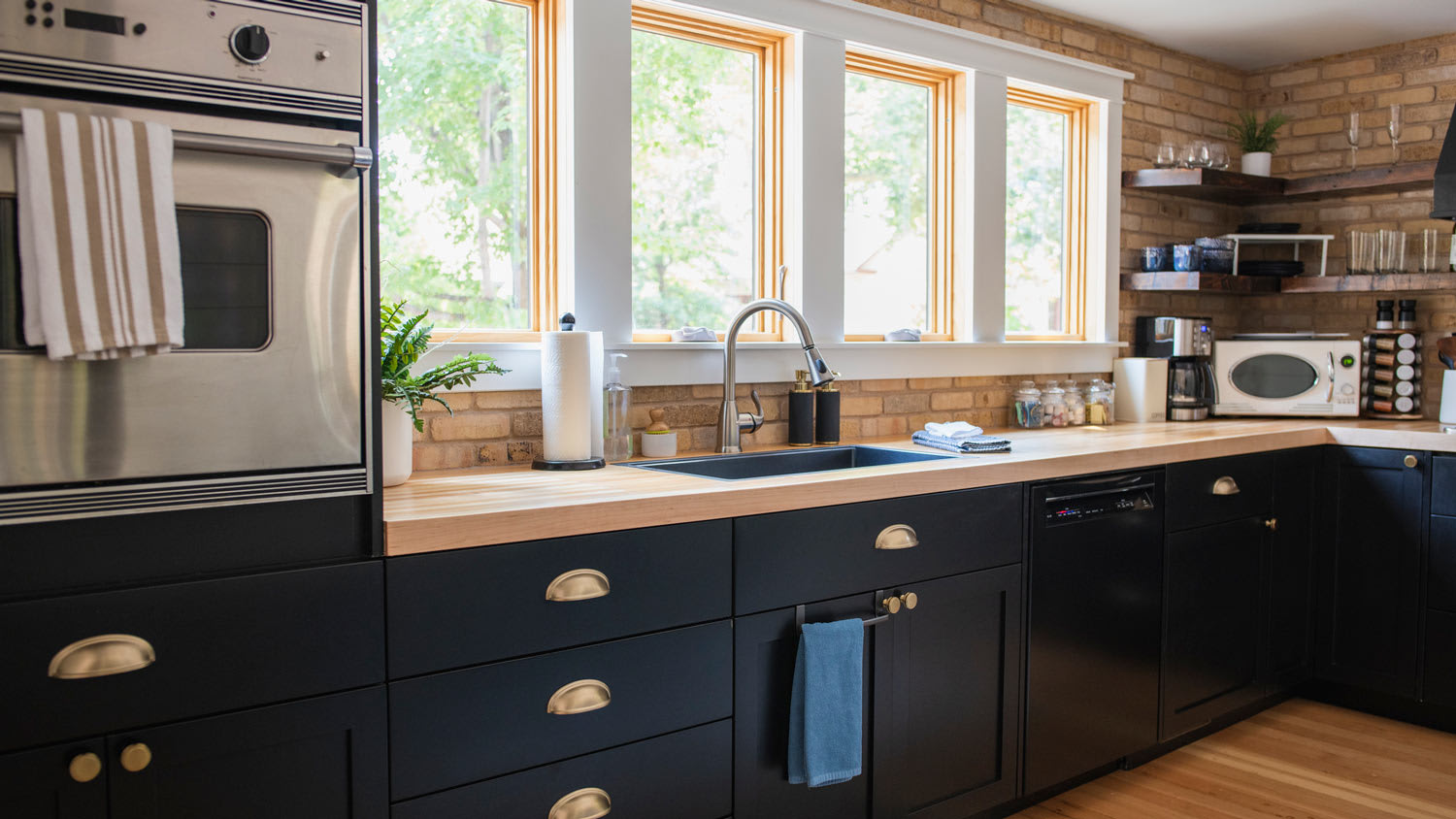 A contemporary kitchen with dark cabinets and appliances