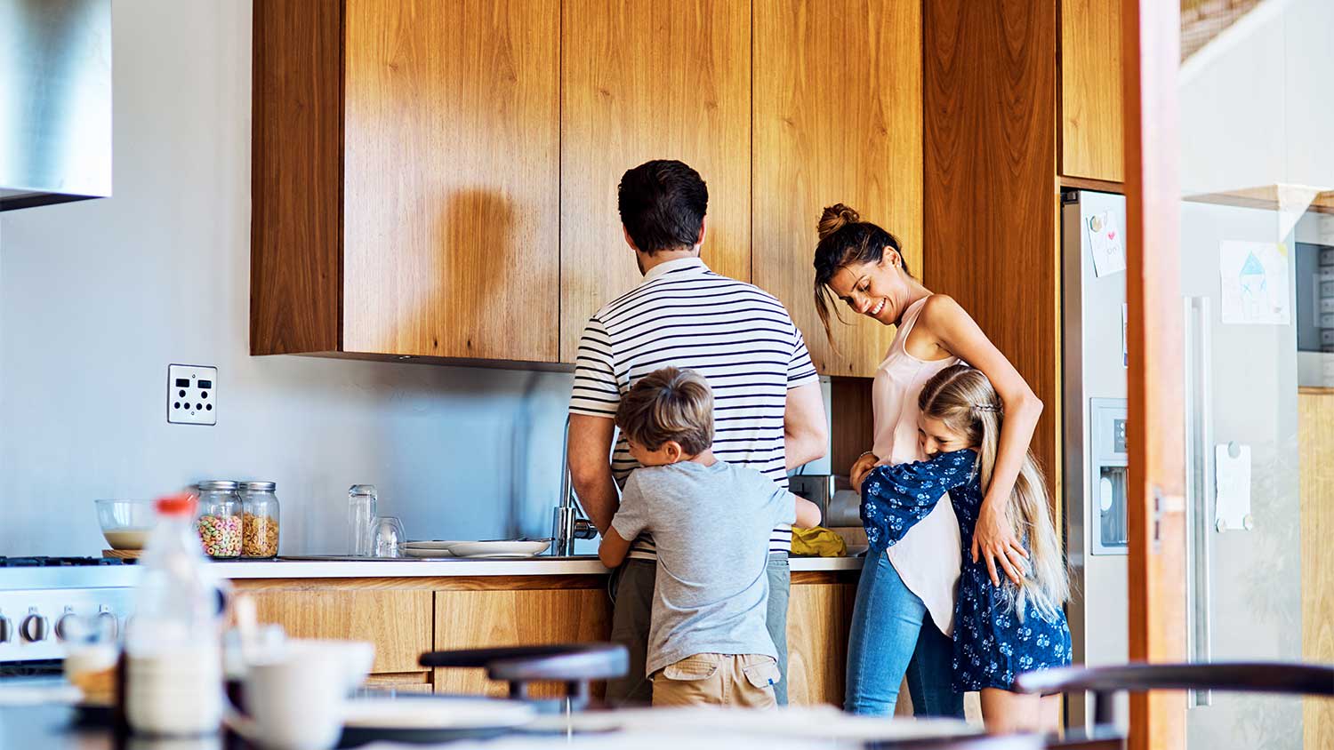 Family hugging in kitchen