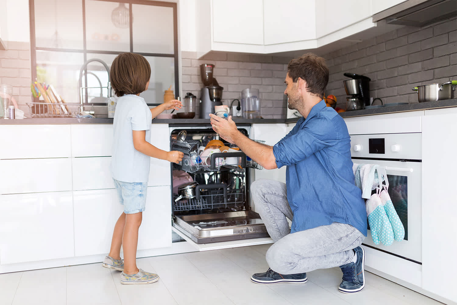 Father and son loading the dishwasher together