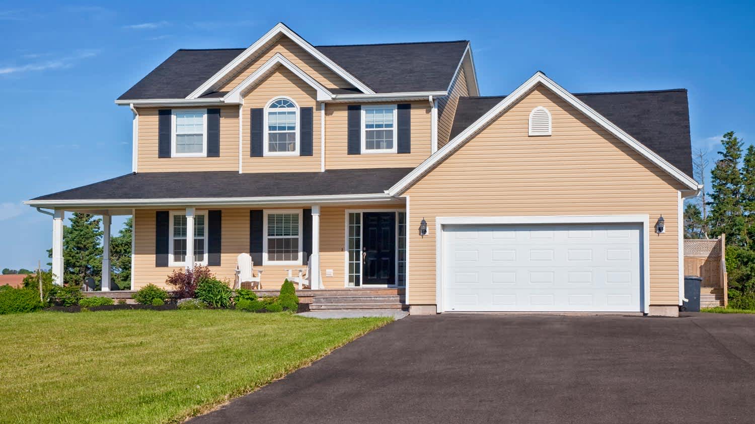 A modern country home with a driveway leading to a garage