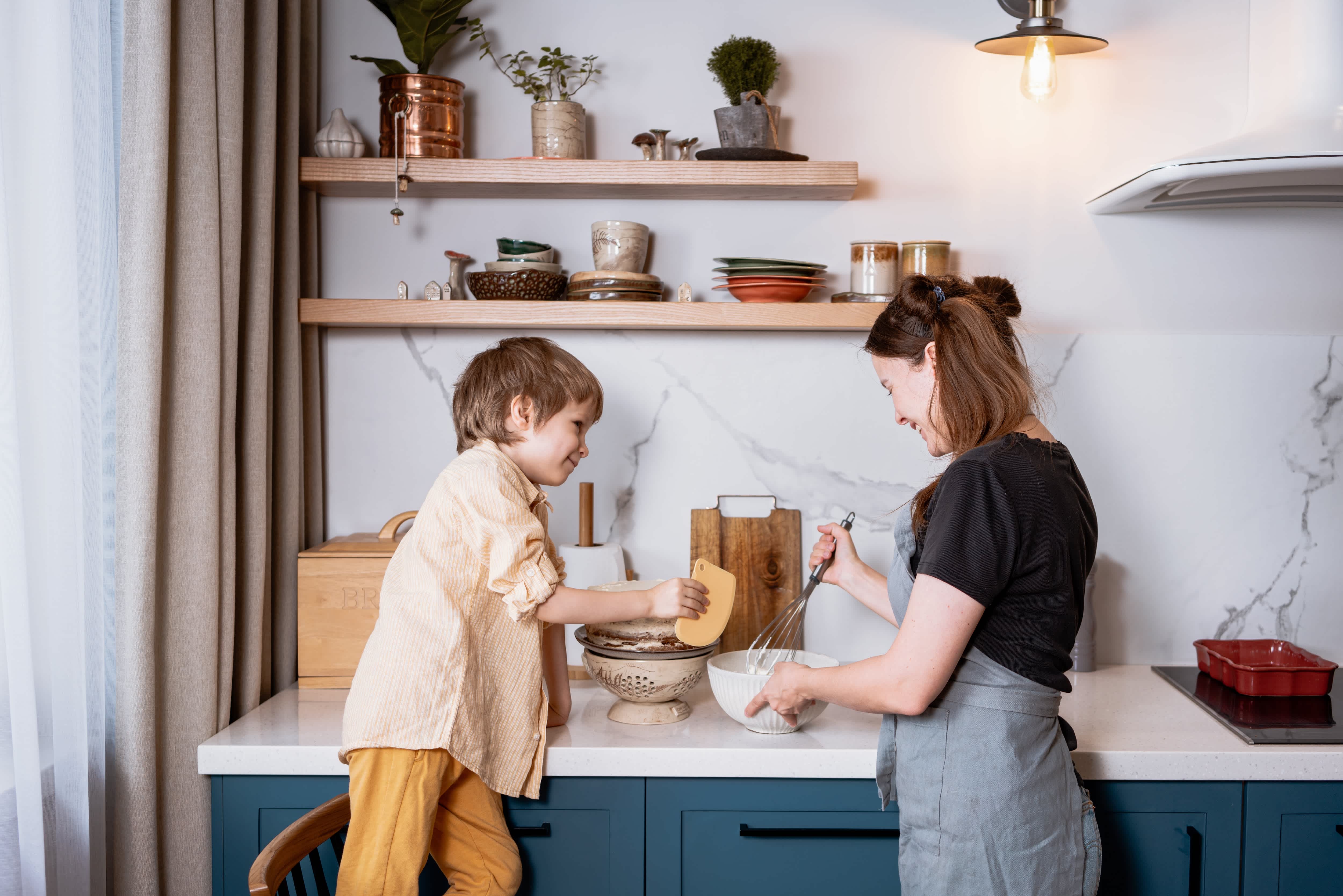 Father and mother baking in kitchen with open shelves