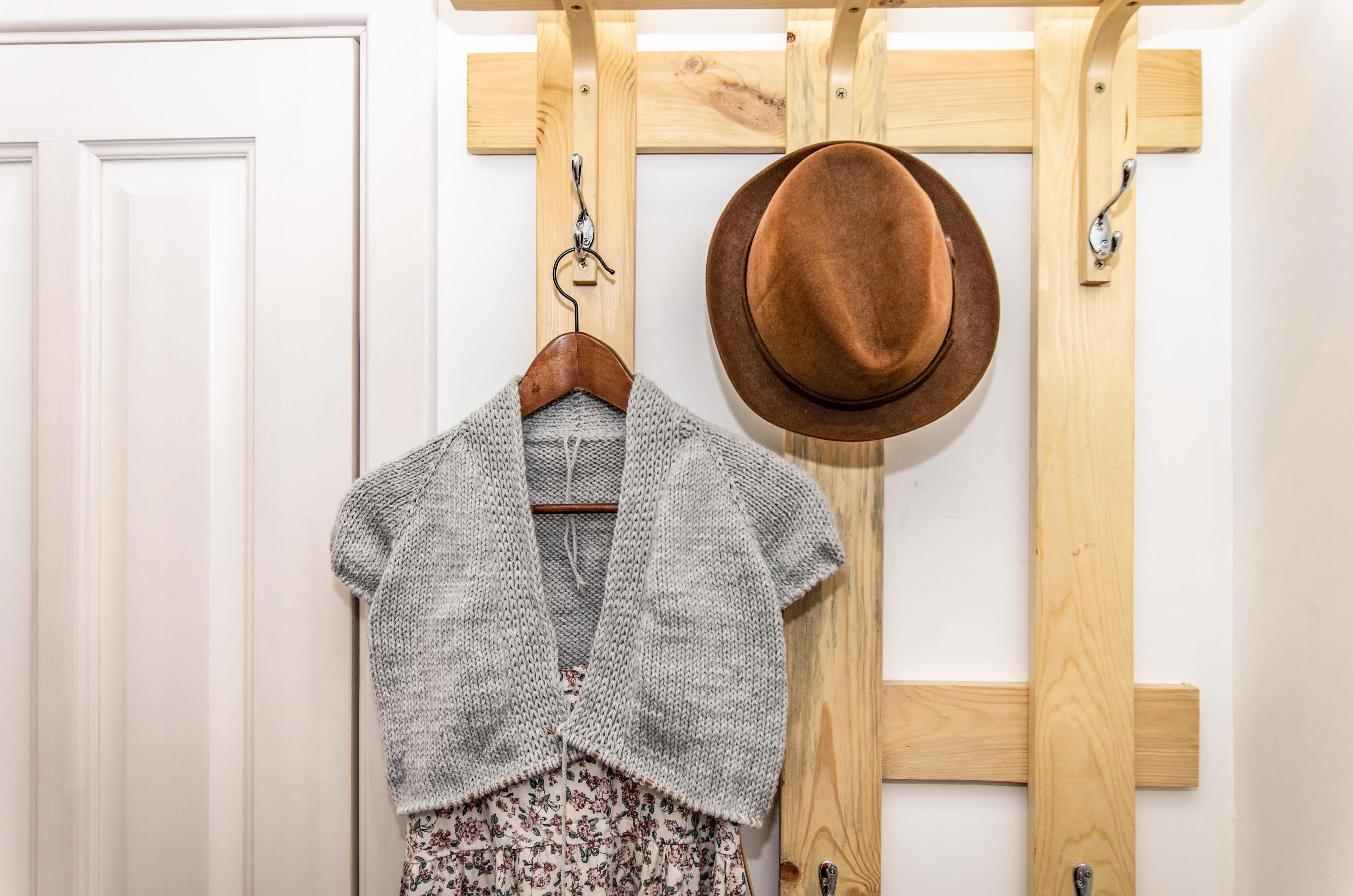 A DIY wooden bracket with hanging hooks in a closet