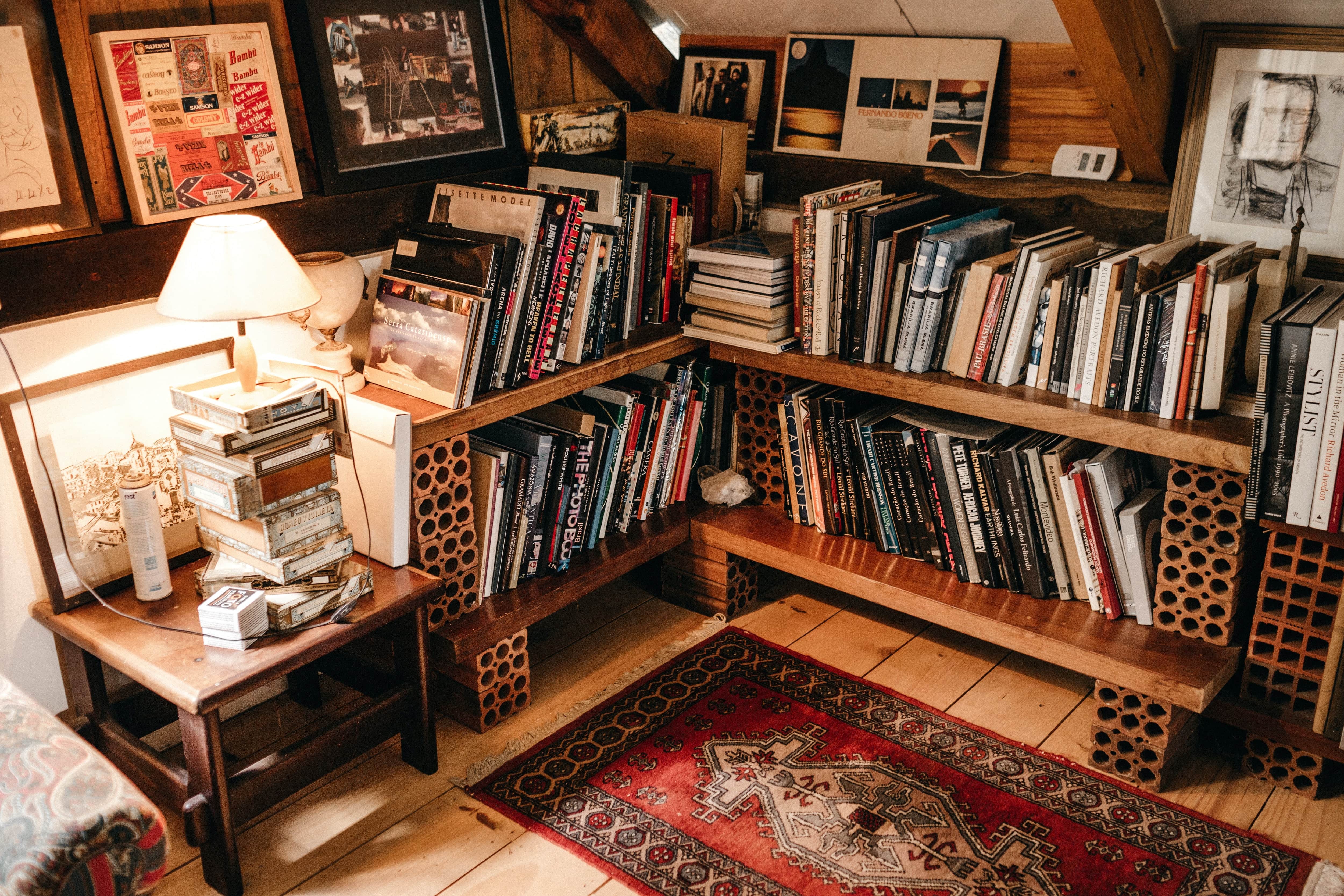 DIY wood L-shaped bookshelf stuffed with books in the corner of a room