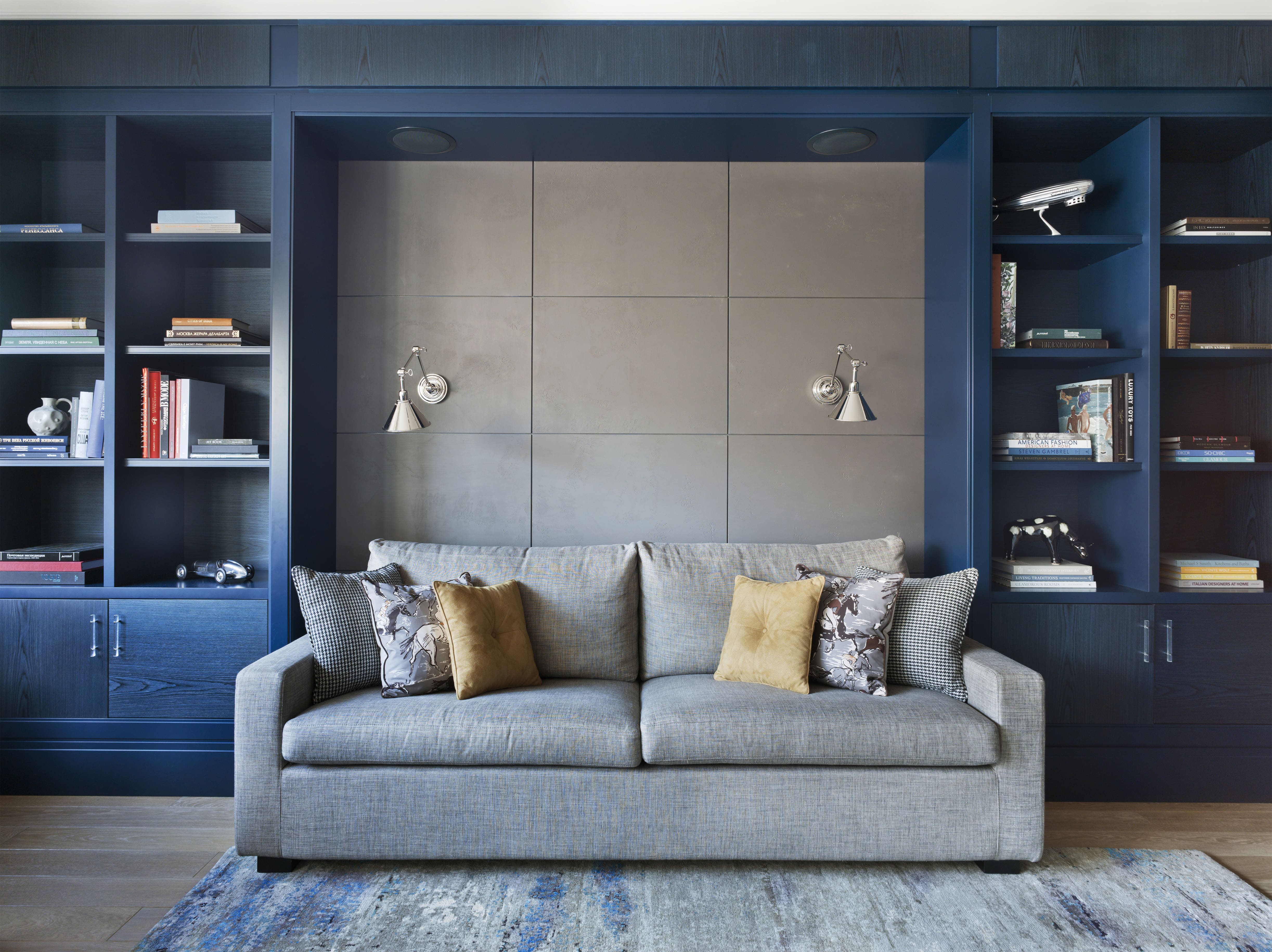 Gray couch in front of blue library bookshelves