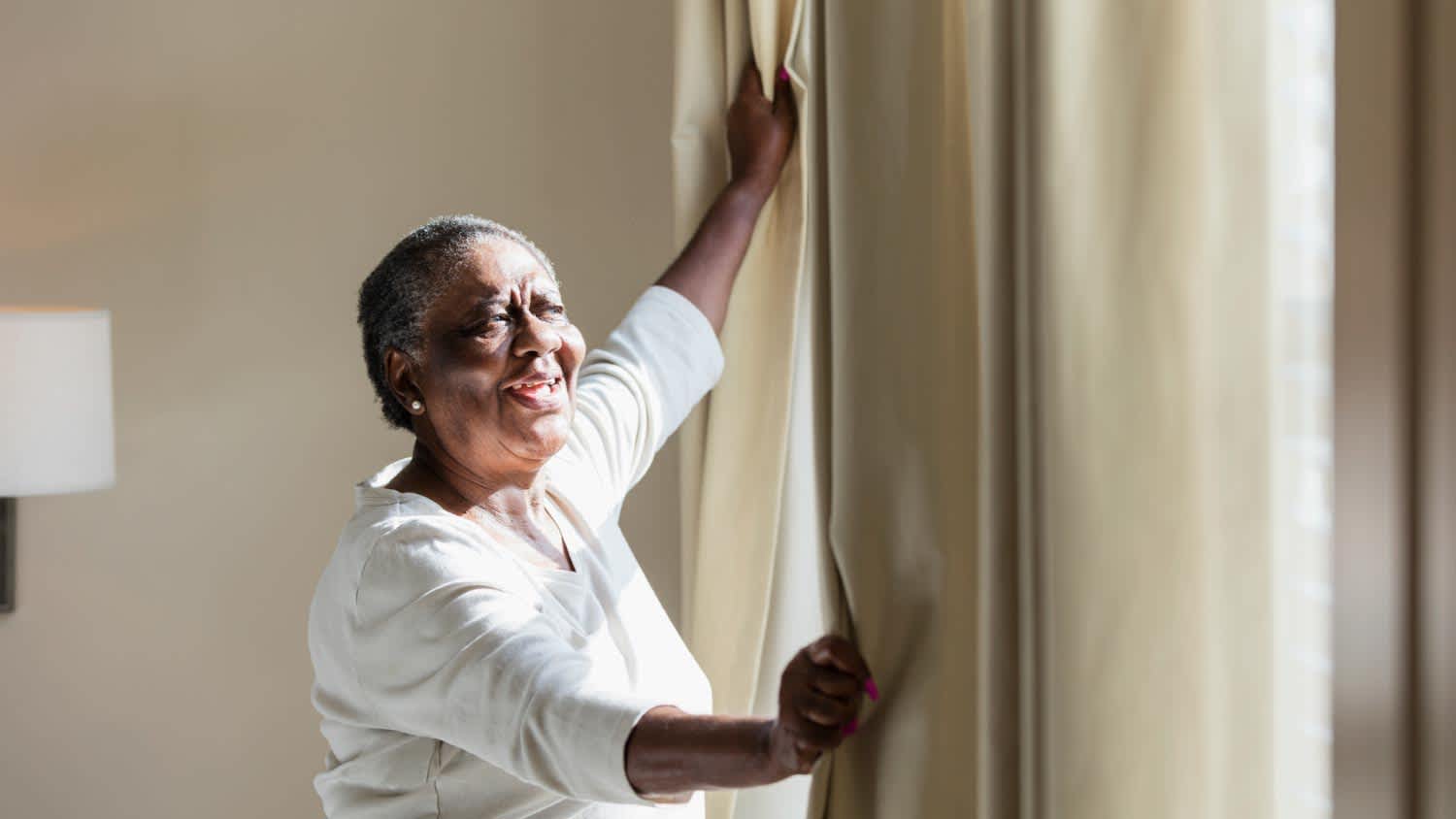 A woman opening curtain