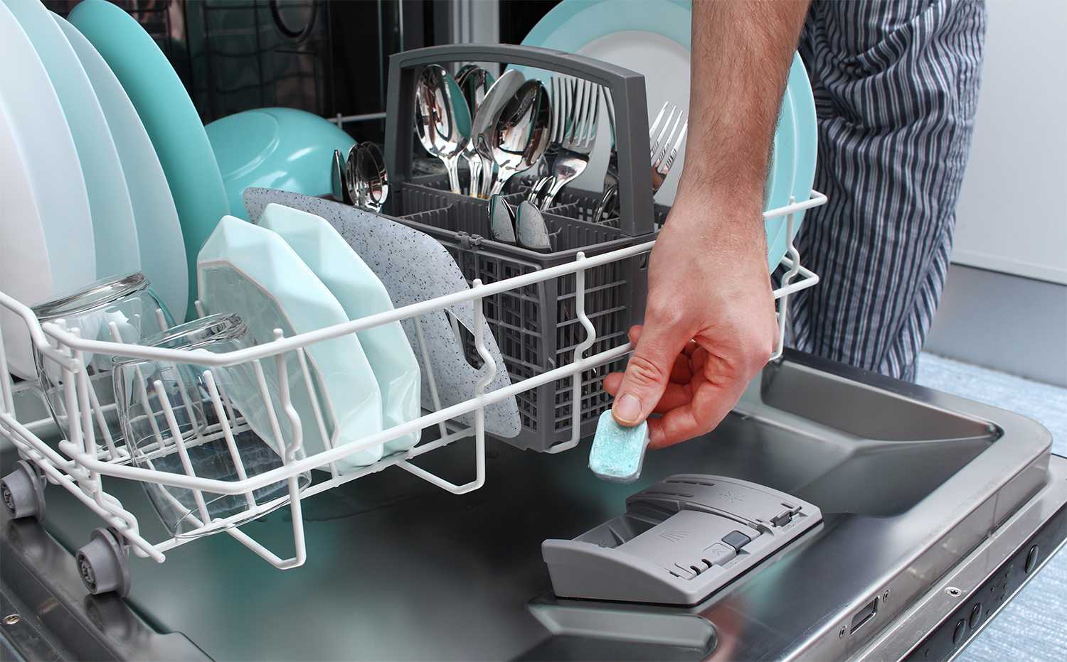 Man putting soap tablet in the dishwasher