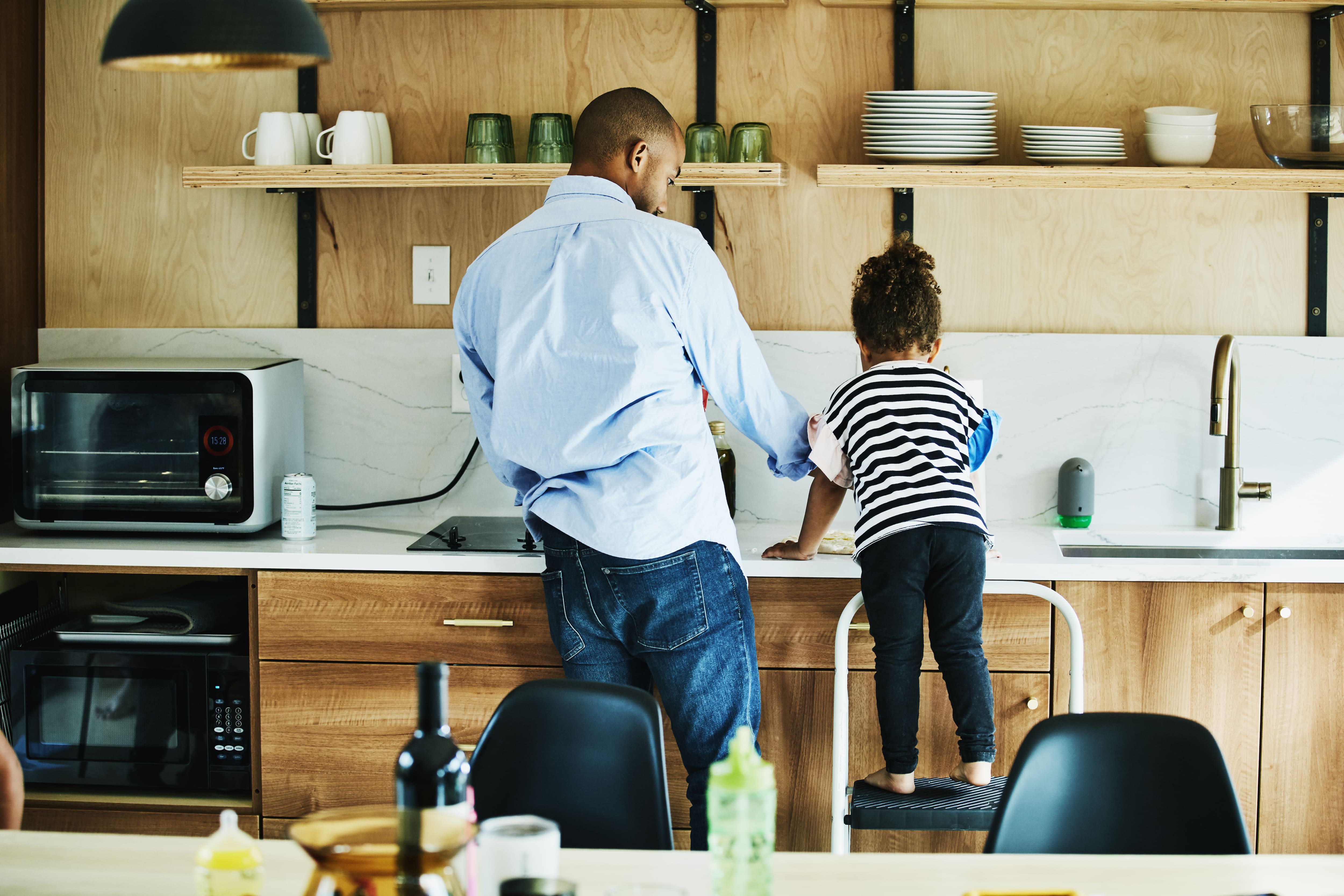 Daughter helping father in kitchen