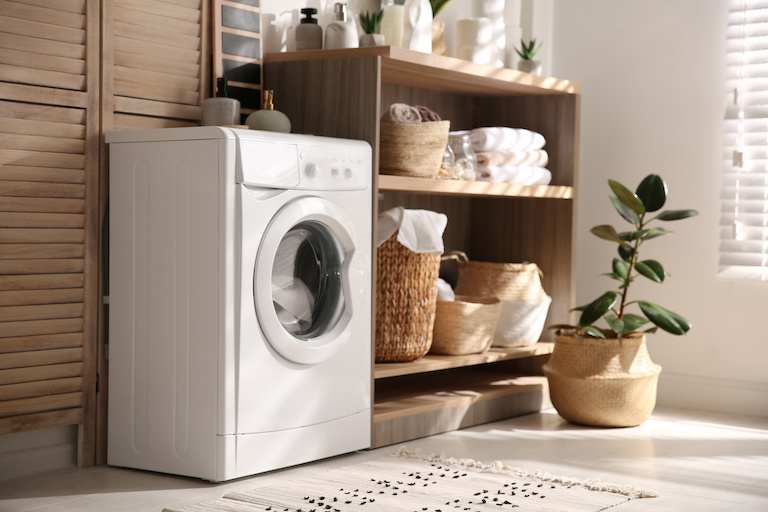 Modern washing machine and shelving unit in laundry room interior