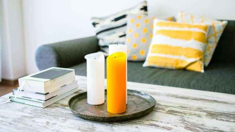 Distressed white coffee table using milk paint with candles and books