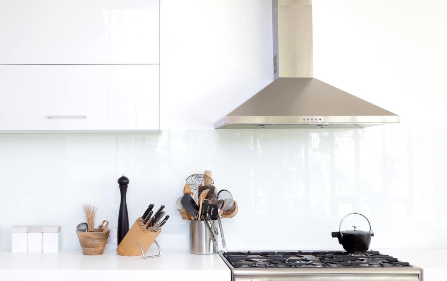 A white modern kitchen with a exhaust fan