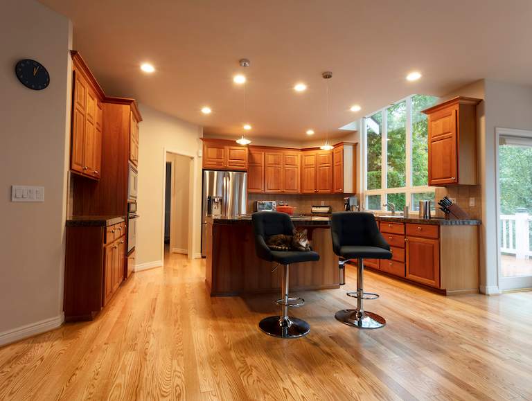 home kitchen with island and bar stools, wood accents, and recessed lighting