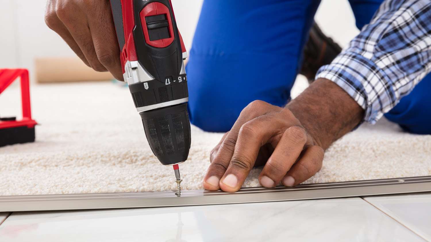 Close-up of a professional installing a carpet