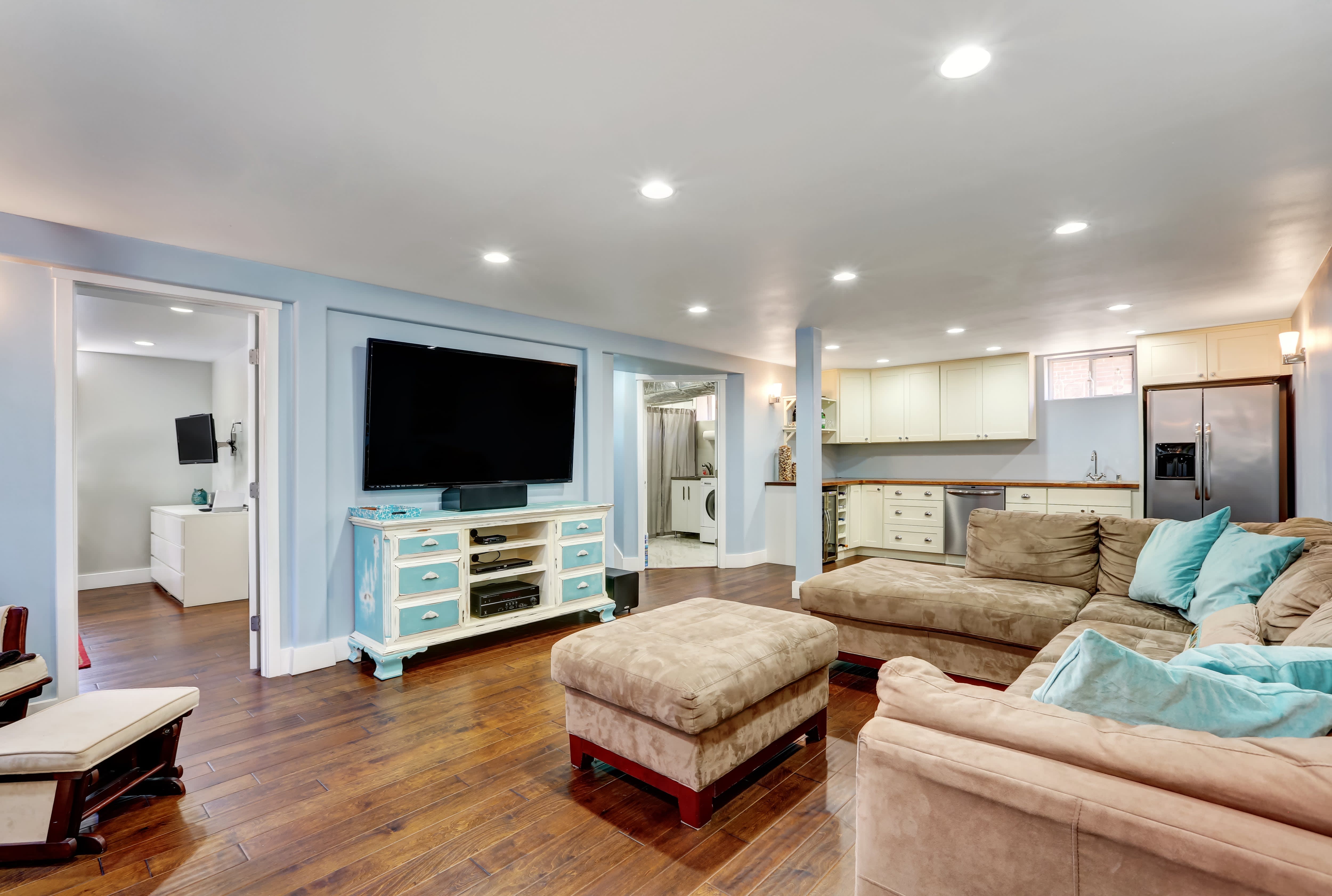 Basement living room with pastel blue walls and taupe sectional