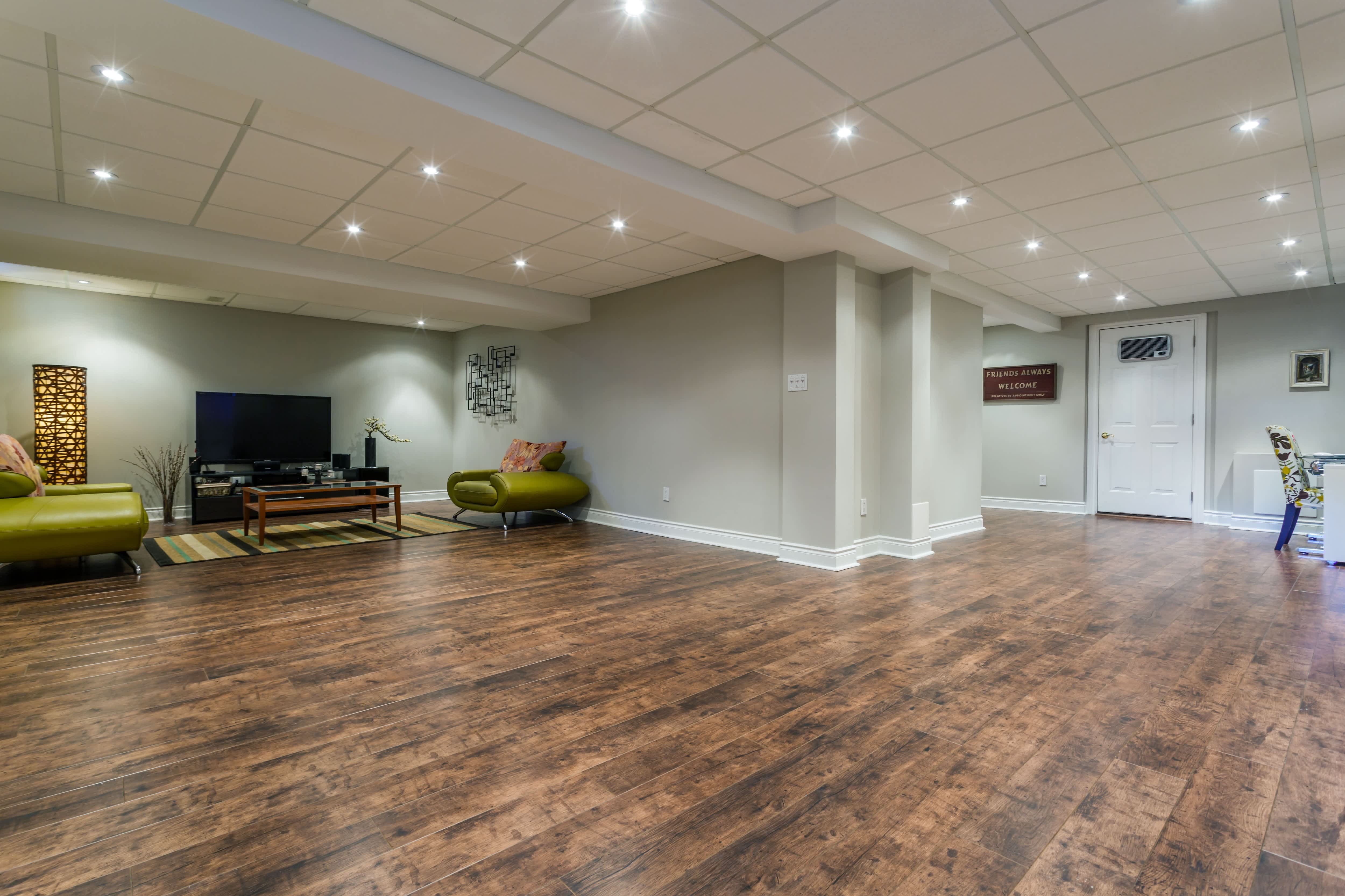 A finished basement with wood floors and ceiling tile
