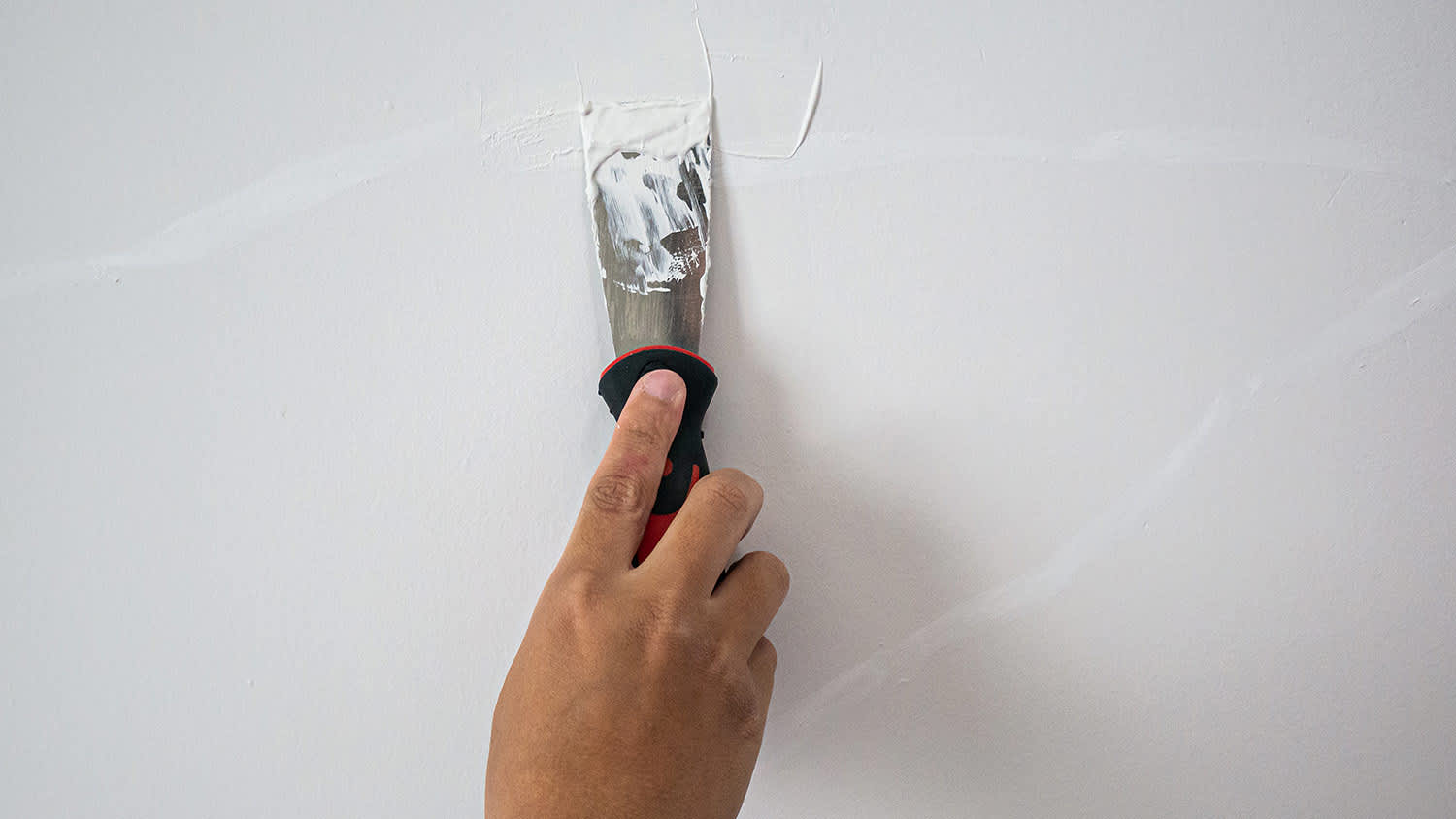 Hand repairing plaster crack
