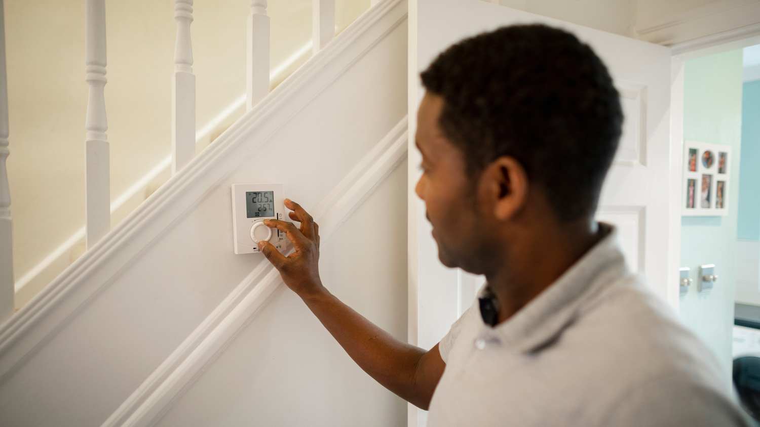 A man turning down the thermostat