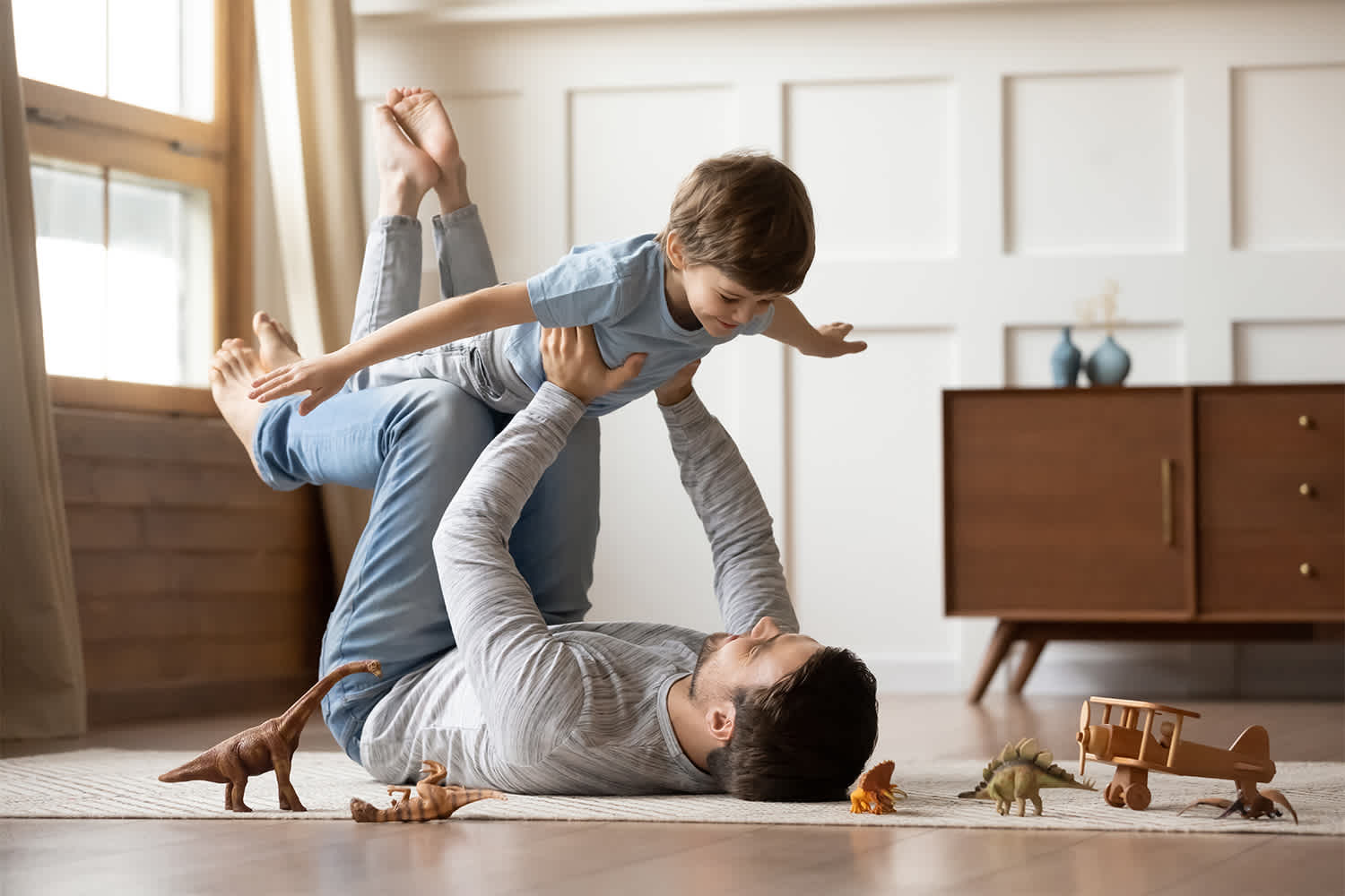 Father carrying daughter on his shoulders at home