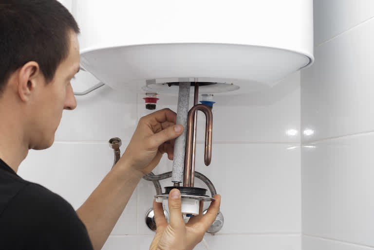 person repairs pipes of water heater