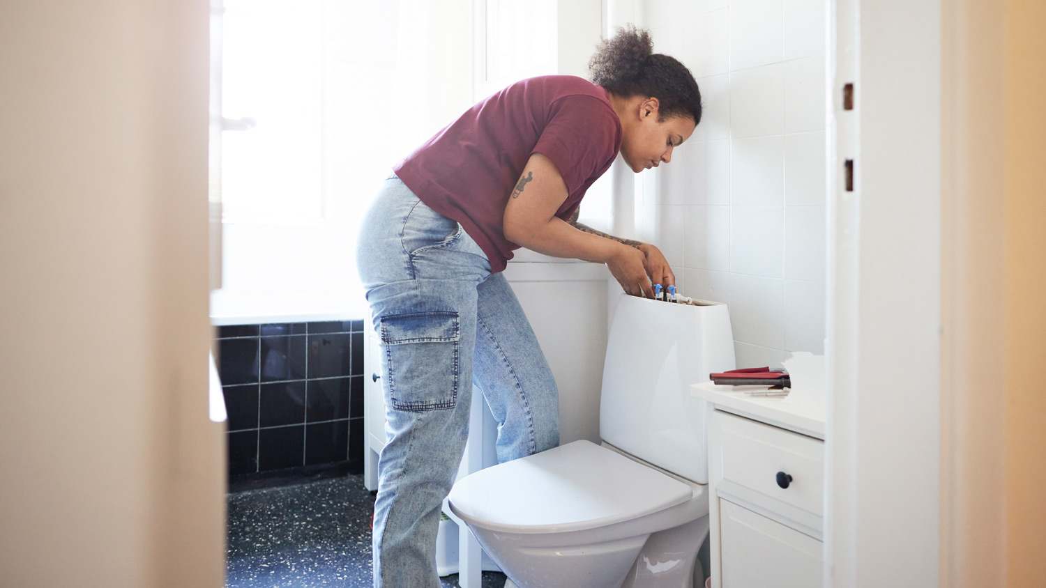 A woman fixing her toilet