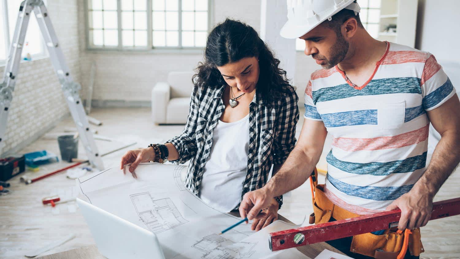 A homeowner and a contractor looking at blueprints