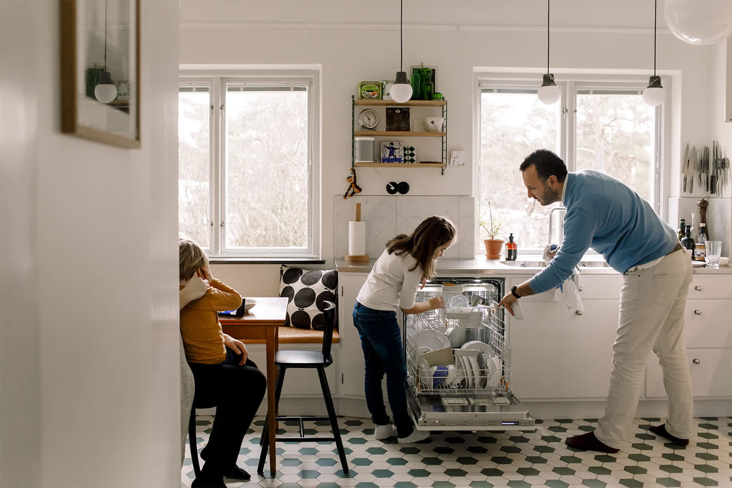 Daughter helping dad unload the dishwasher