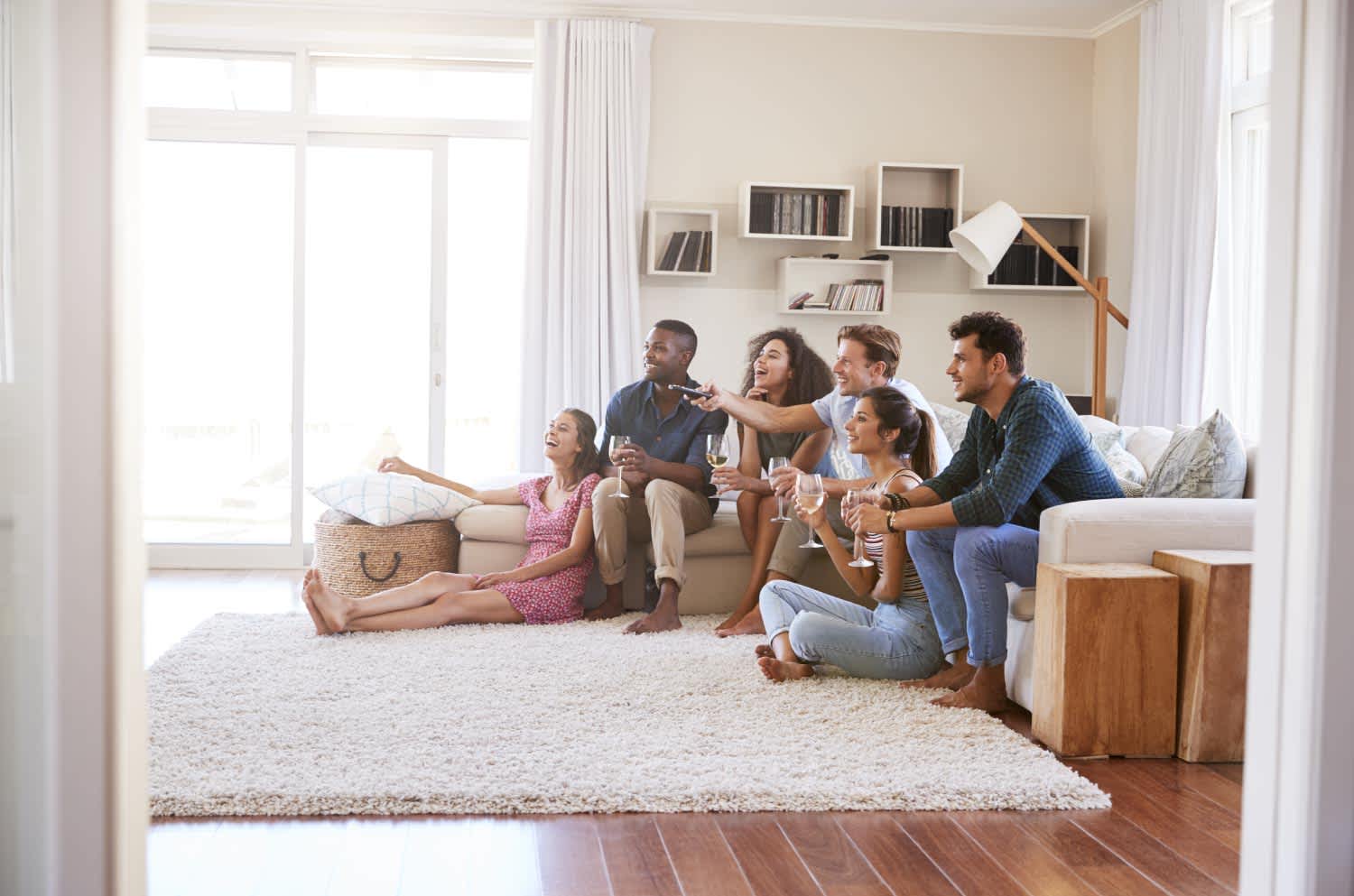 Group of friends relaxing at home watching TV together