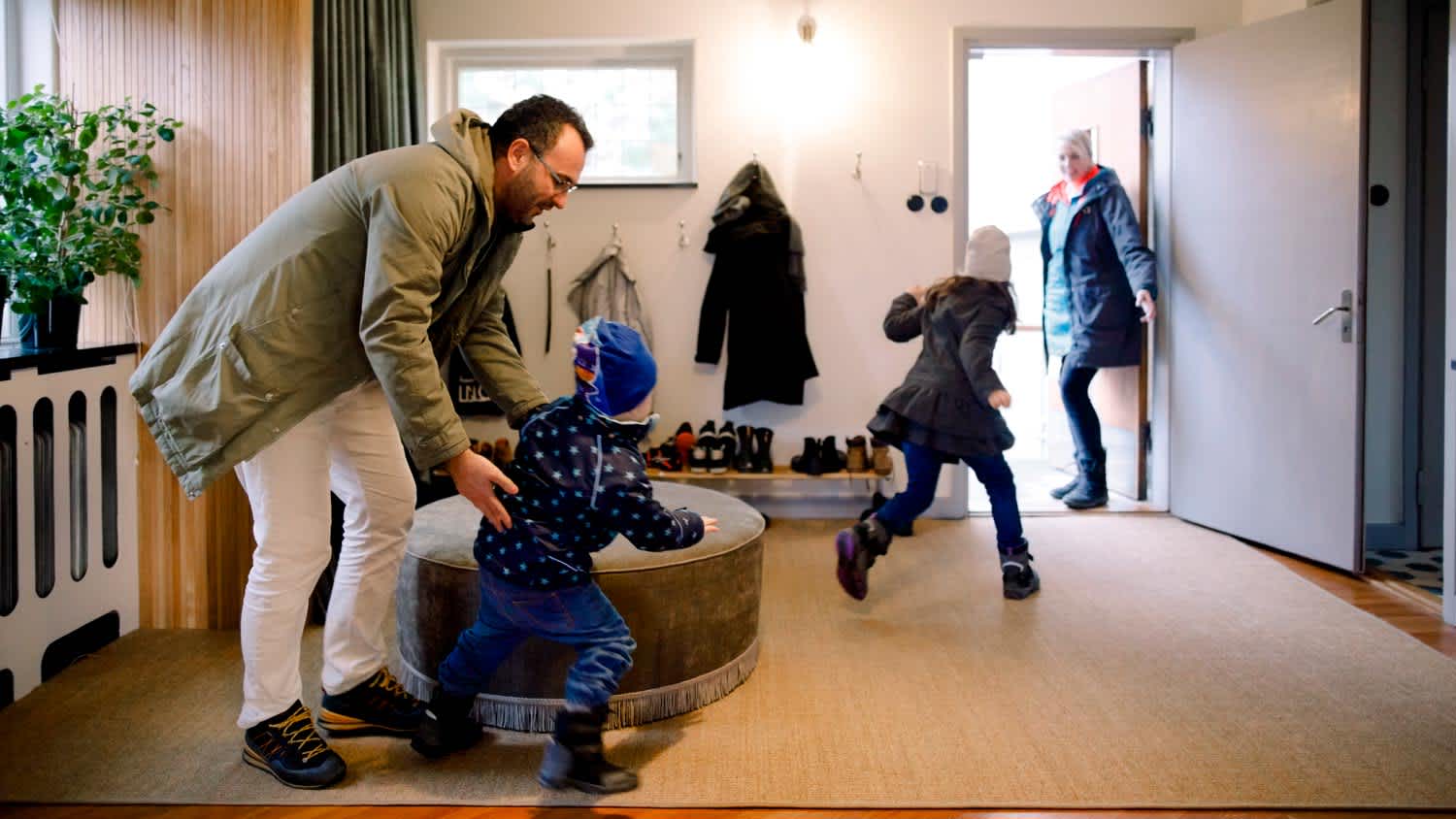 A family putting their coats on in house’s mudroom
