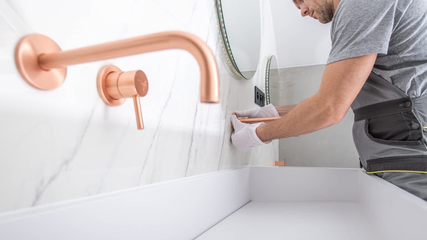 A worker installing a copper faucet