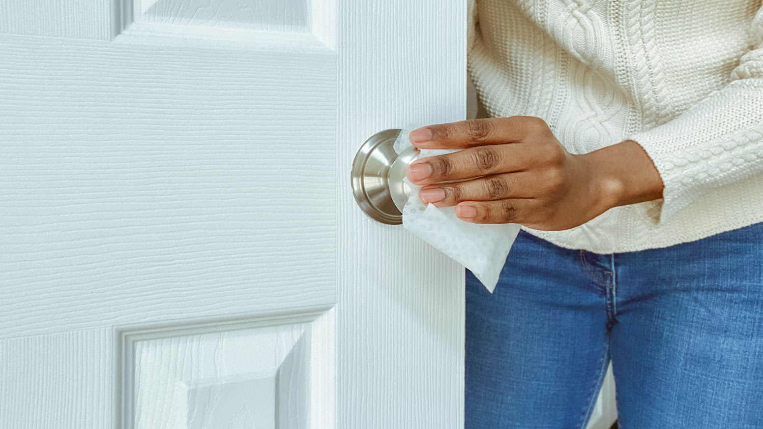 Close-up of a woman cleaning a door knob