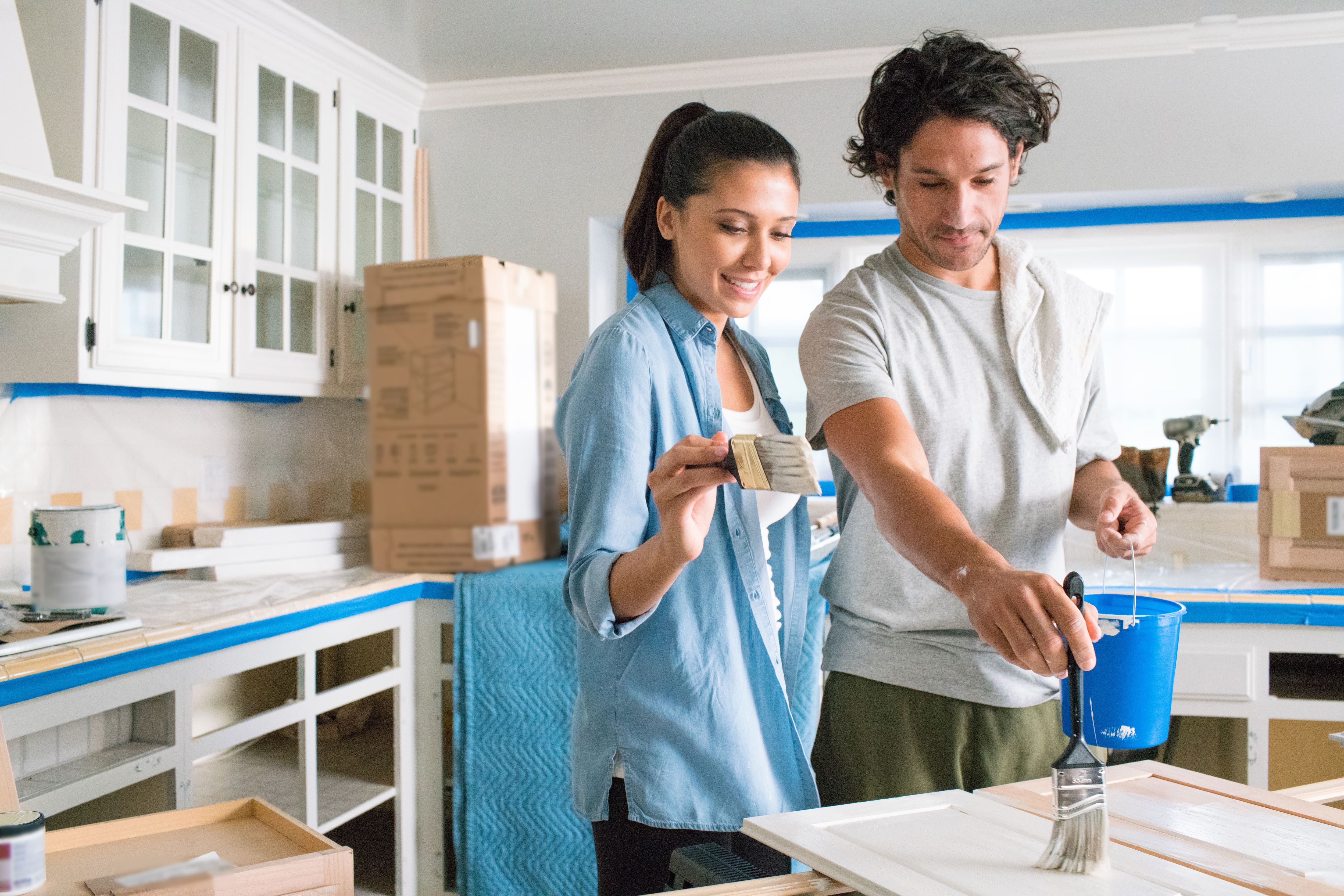 Couple painting cabinets white