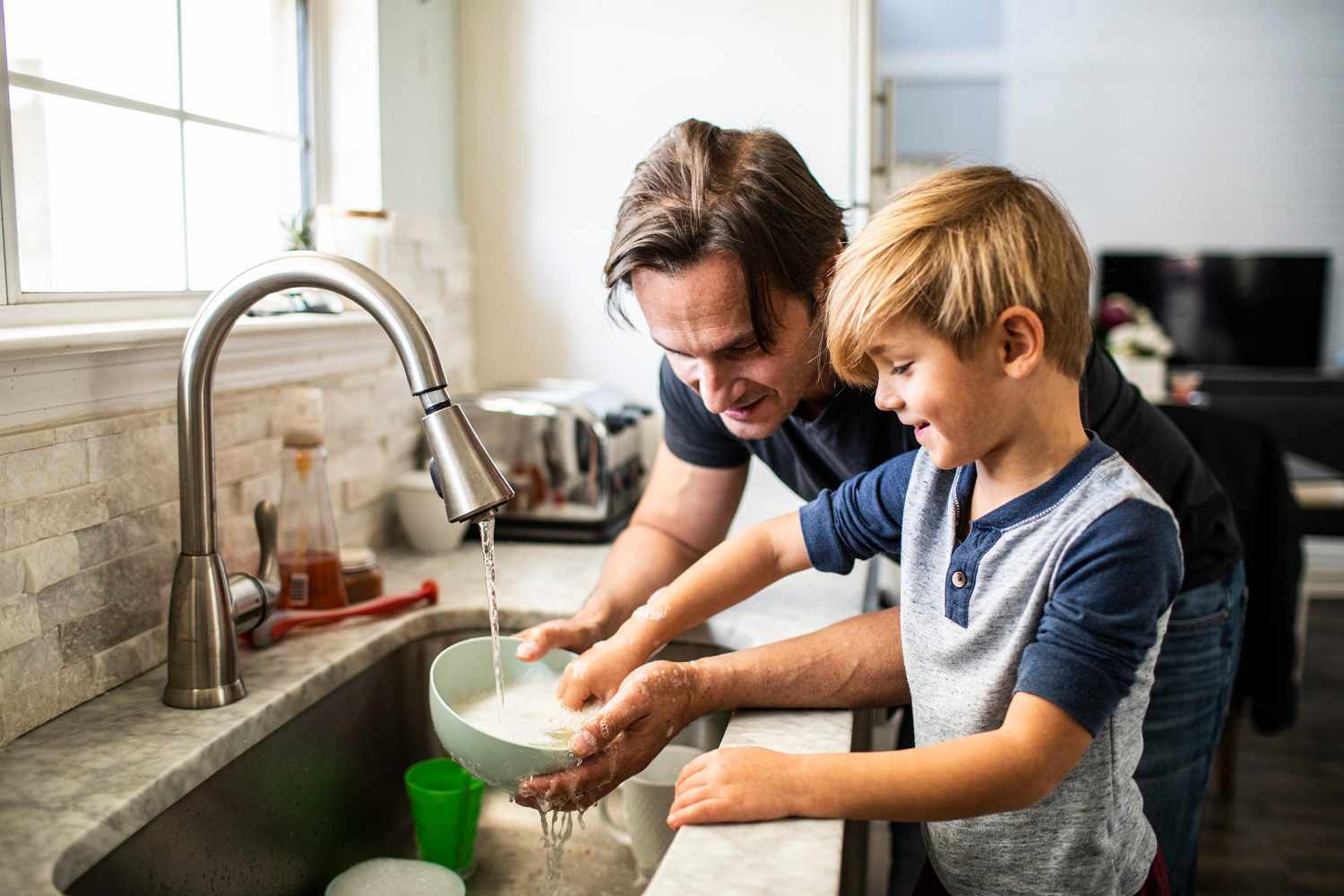 A father and his son doing the dishes
