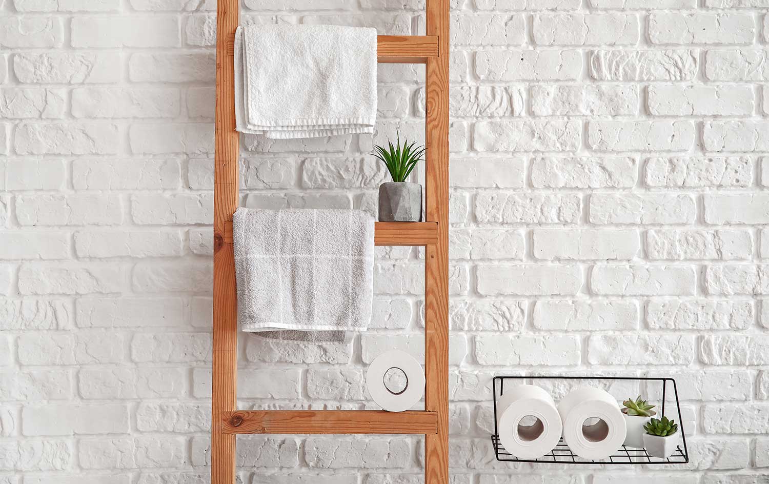 Wooden towel ladder against a brick wall