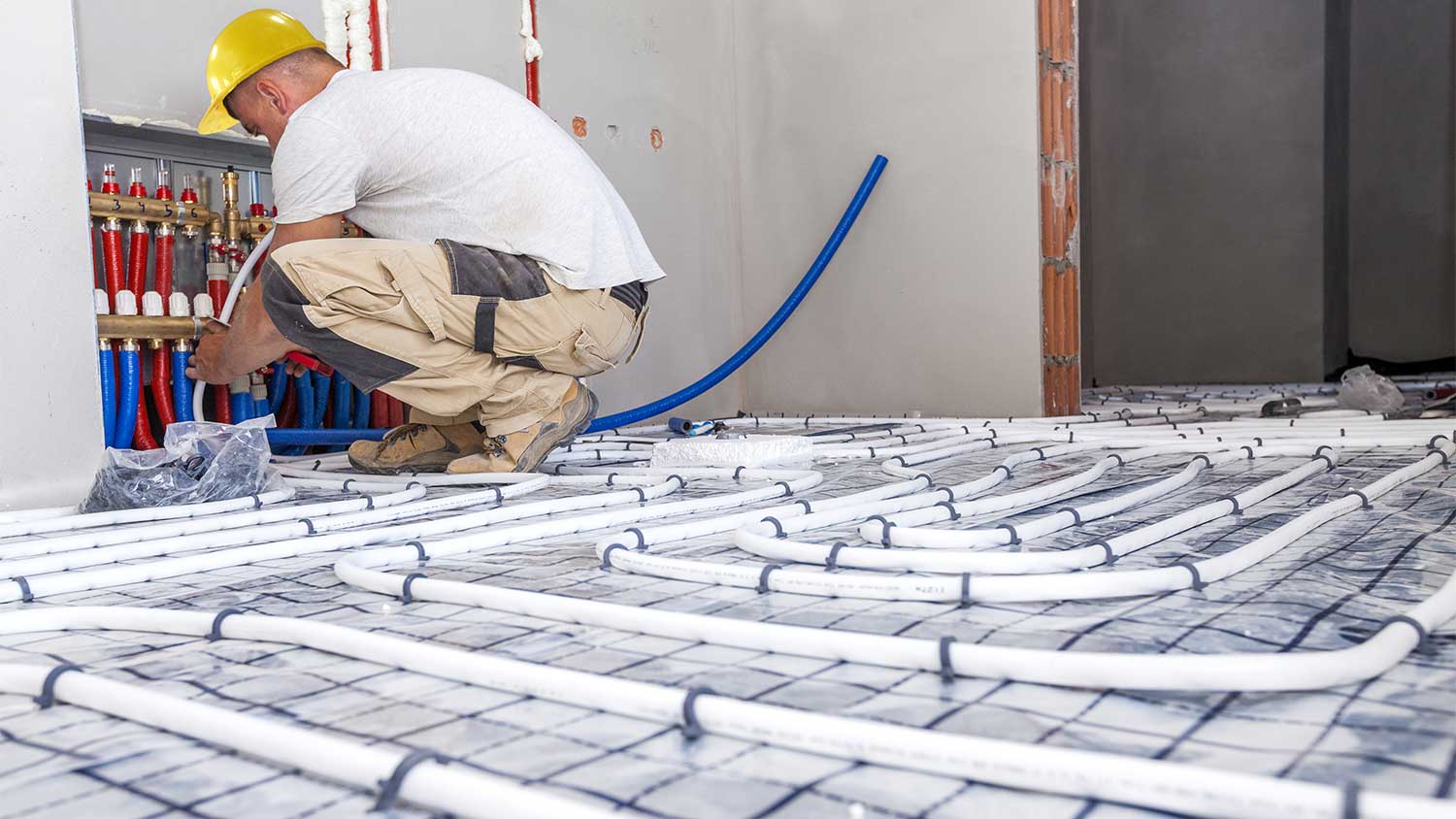Plumber installing new floor heating system