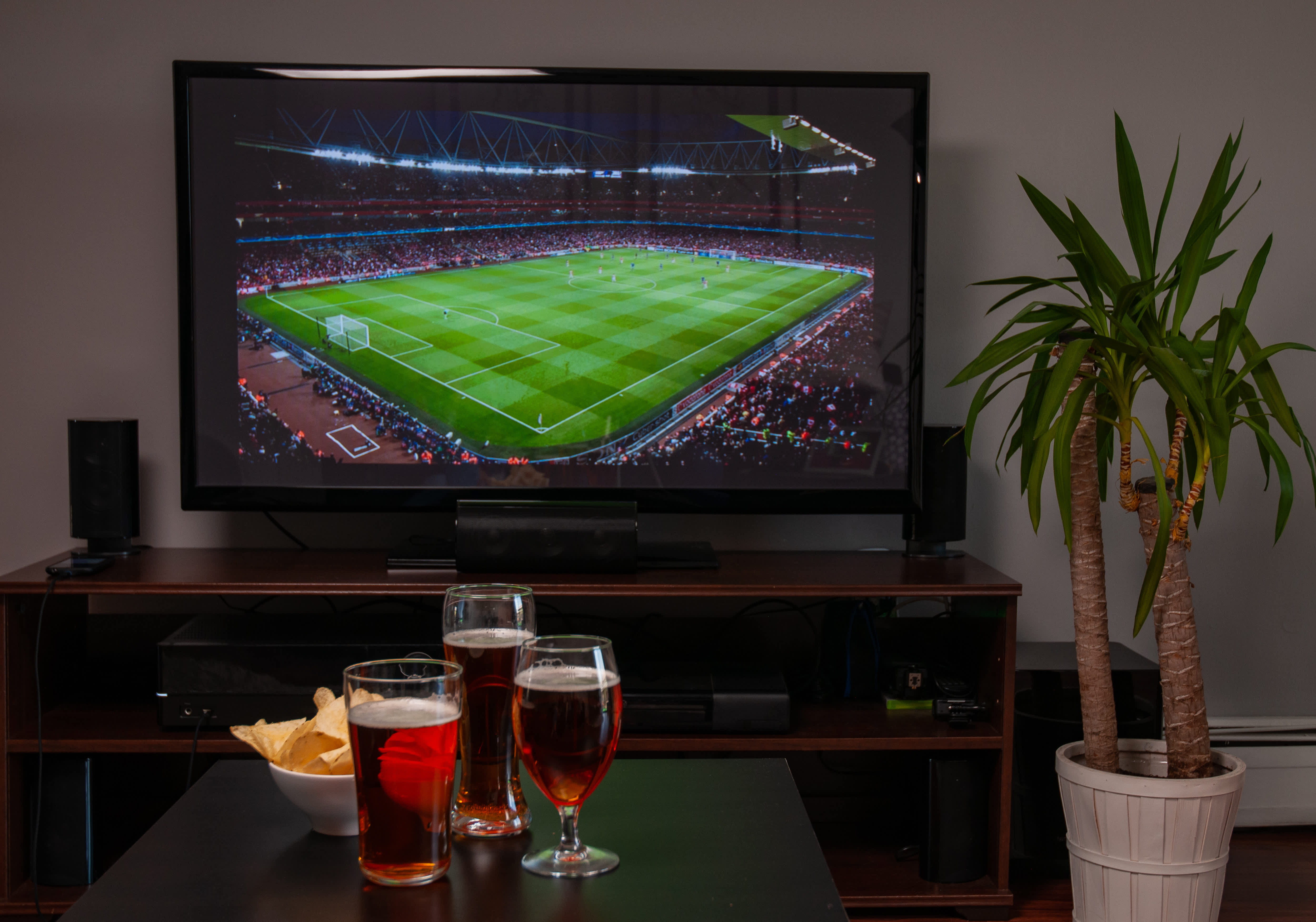 Beer and chips in front of TV with a soccer match on