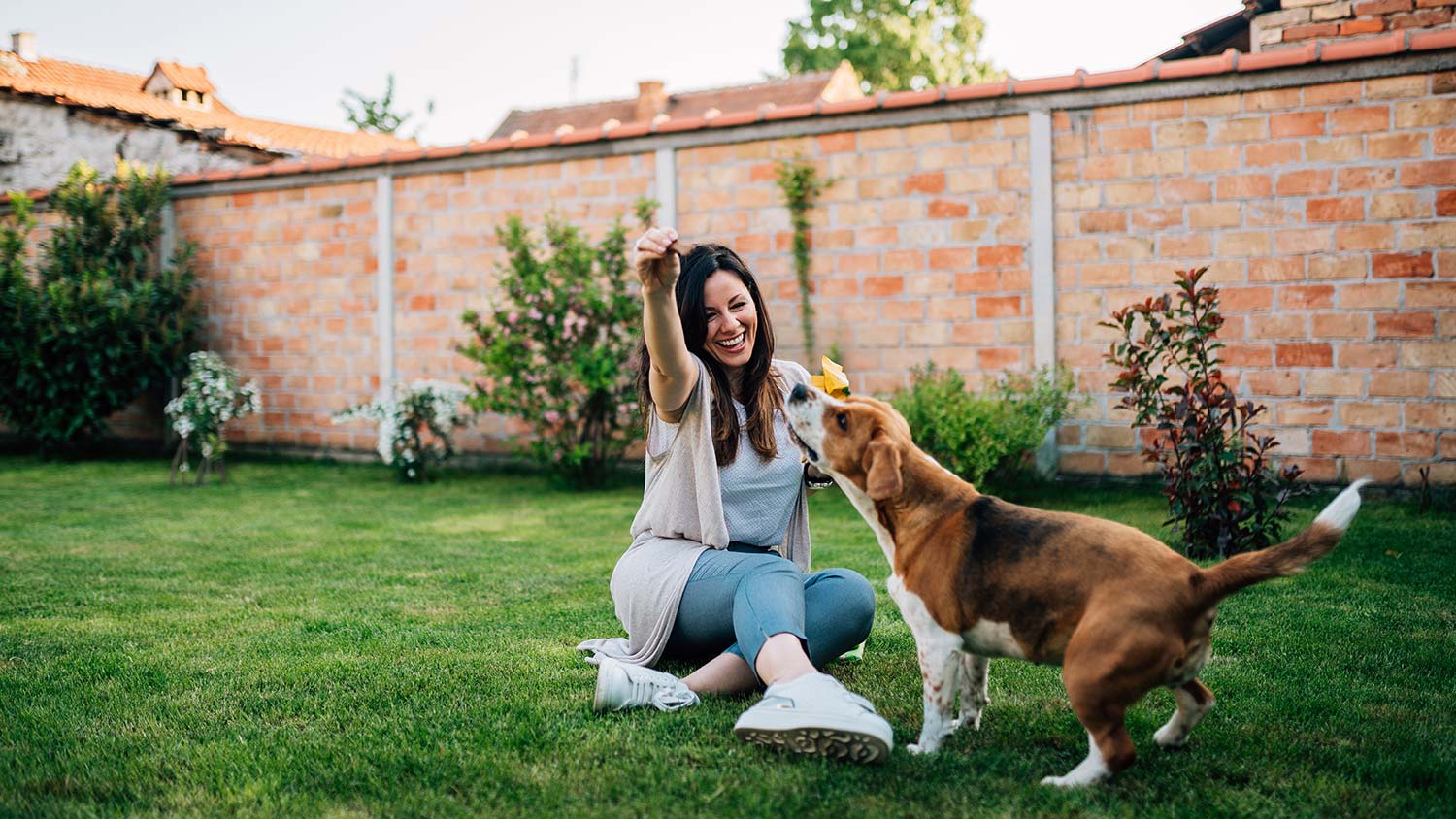 Girl plays with dog in the yard