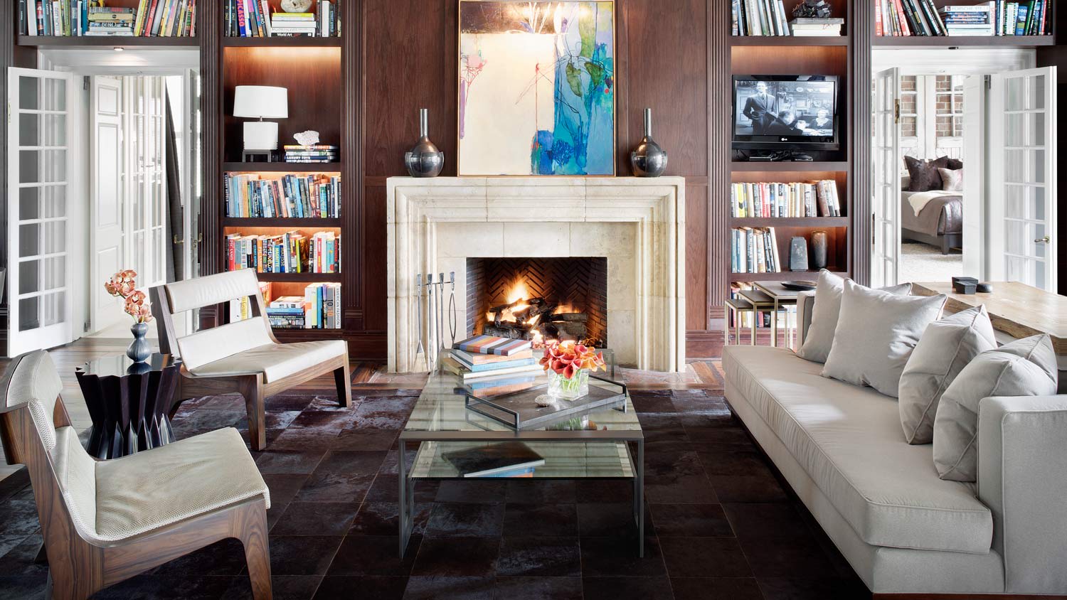 A living room with lots of books and a fireplace