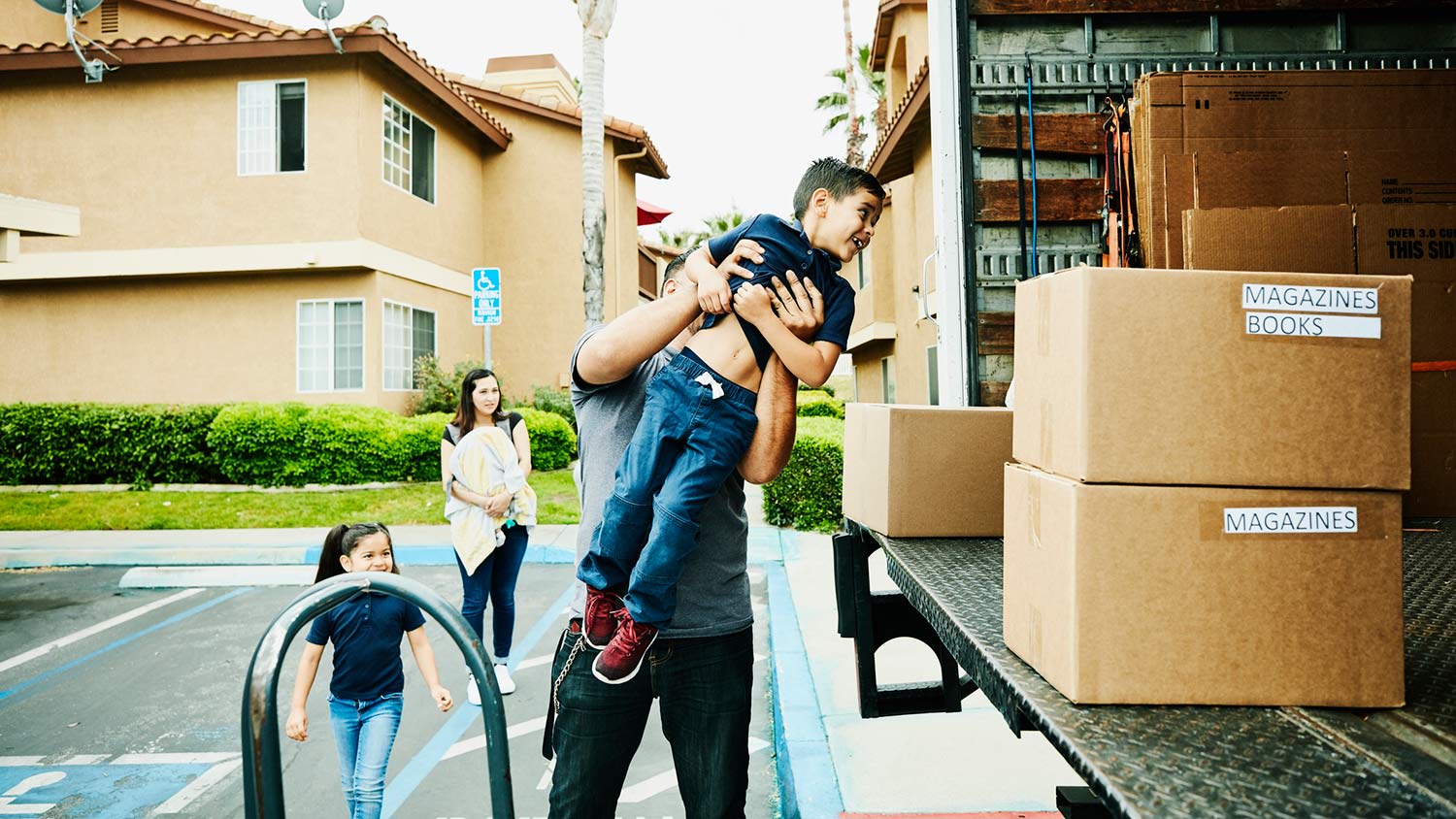 Father lifts son into moving truck
