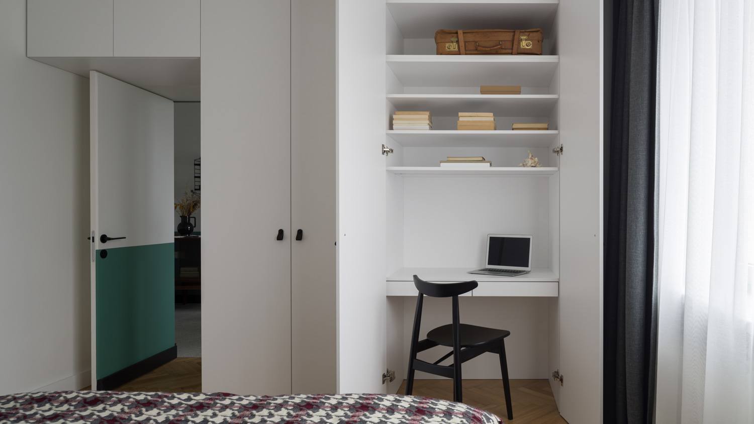 A desk situated inside a wardrobe in a room