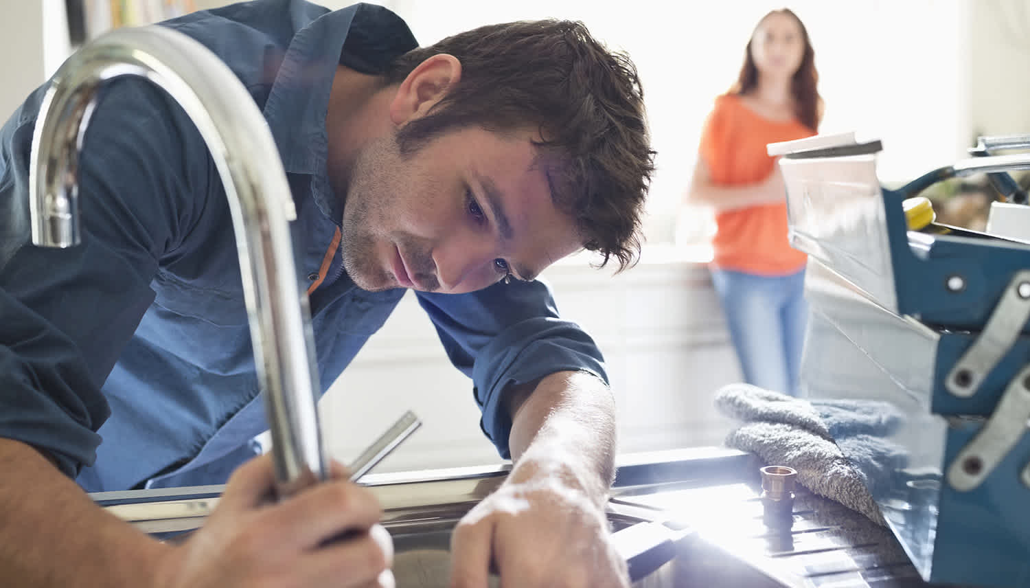Plumber places faucet in sink
