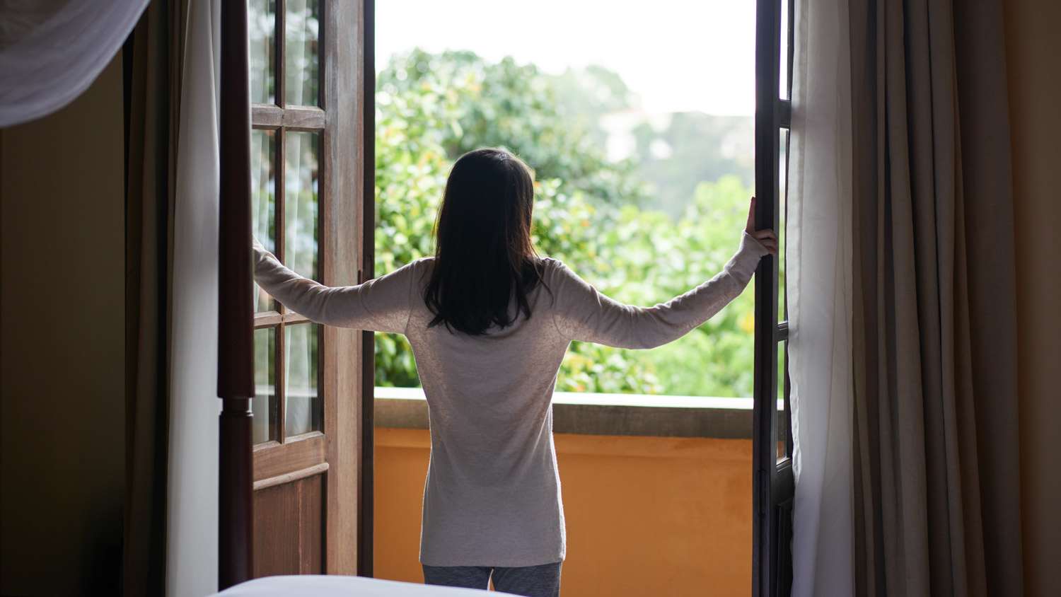 A woman opening a window