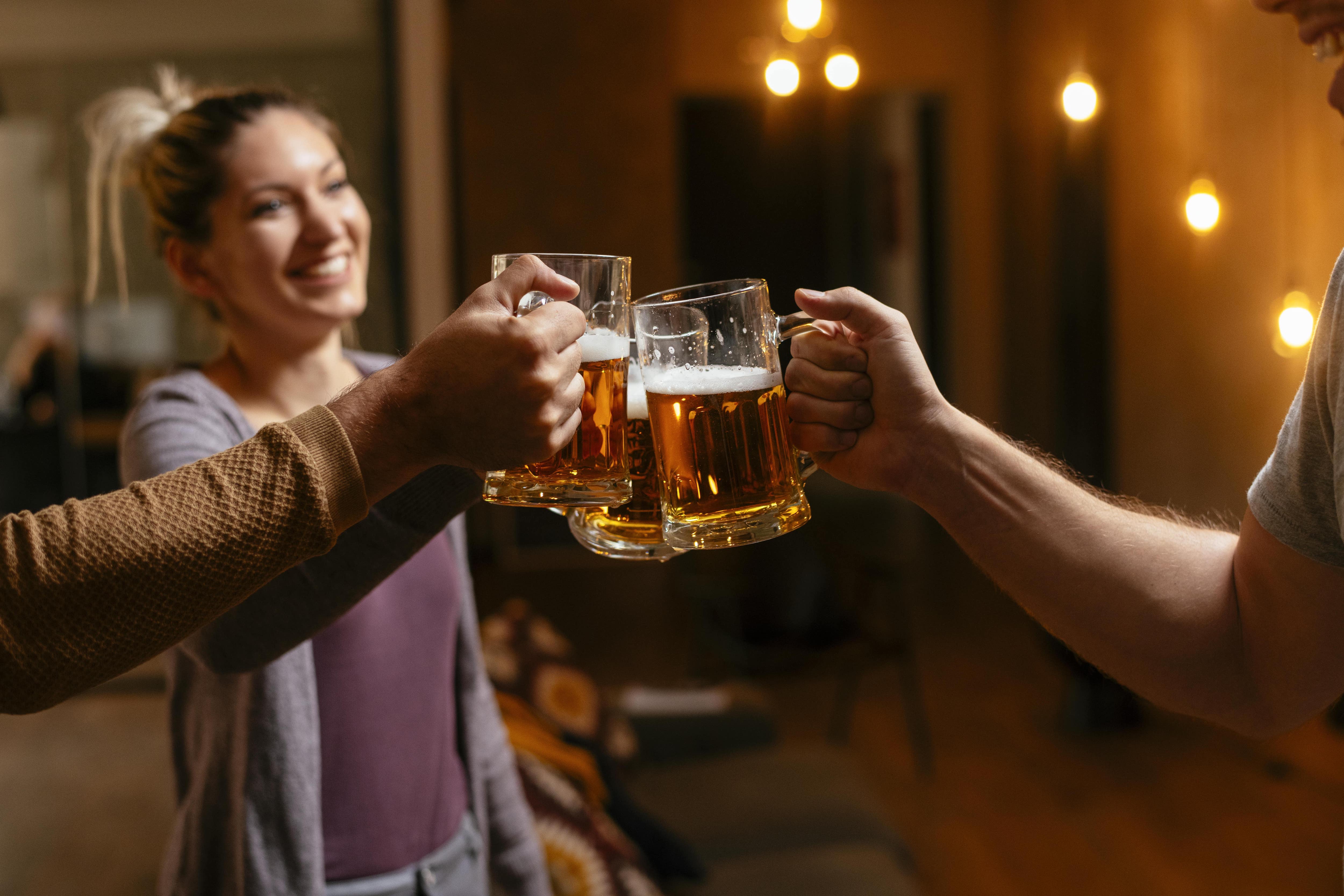 Group of friends clinking beer glasses in a basement bar