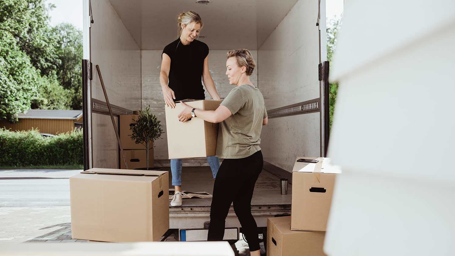 Women unload boxes from moving van
