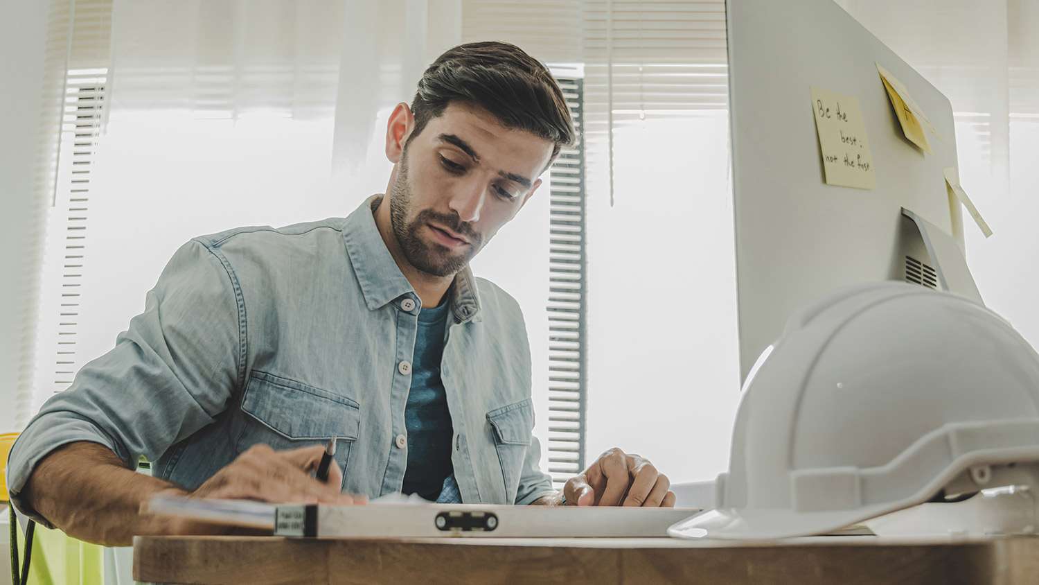 Contractor works on paperwork at desk