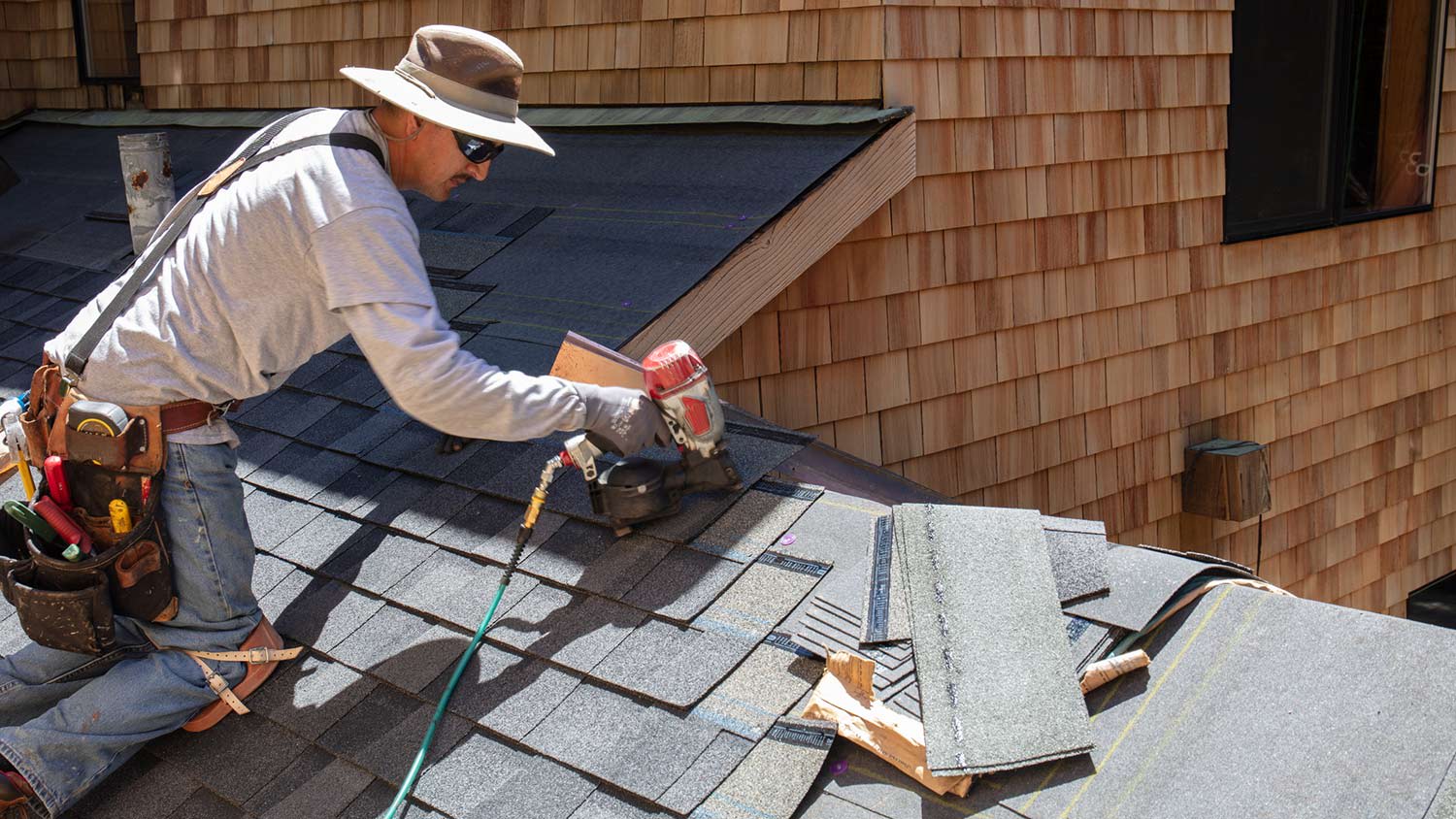 Roofer installs asphalt shingles