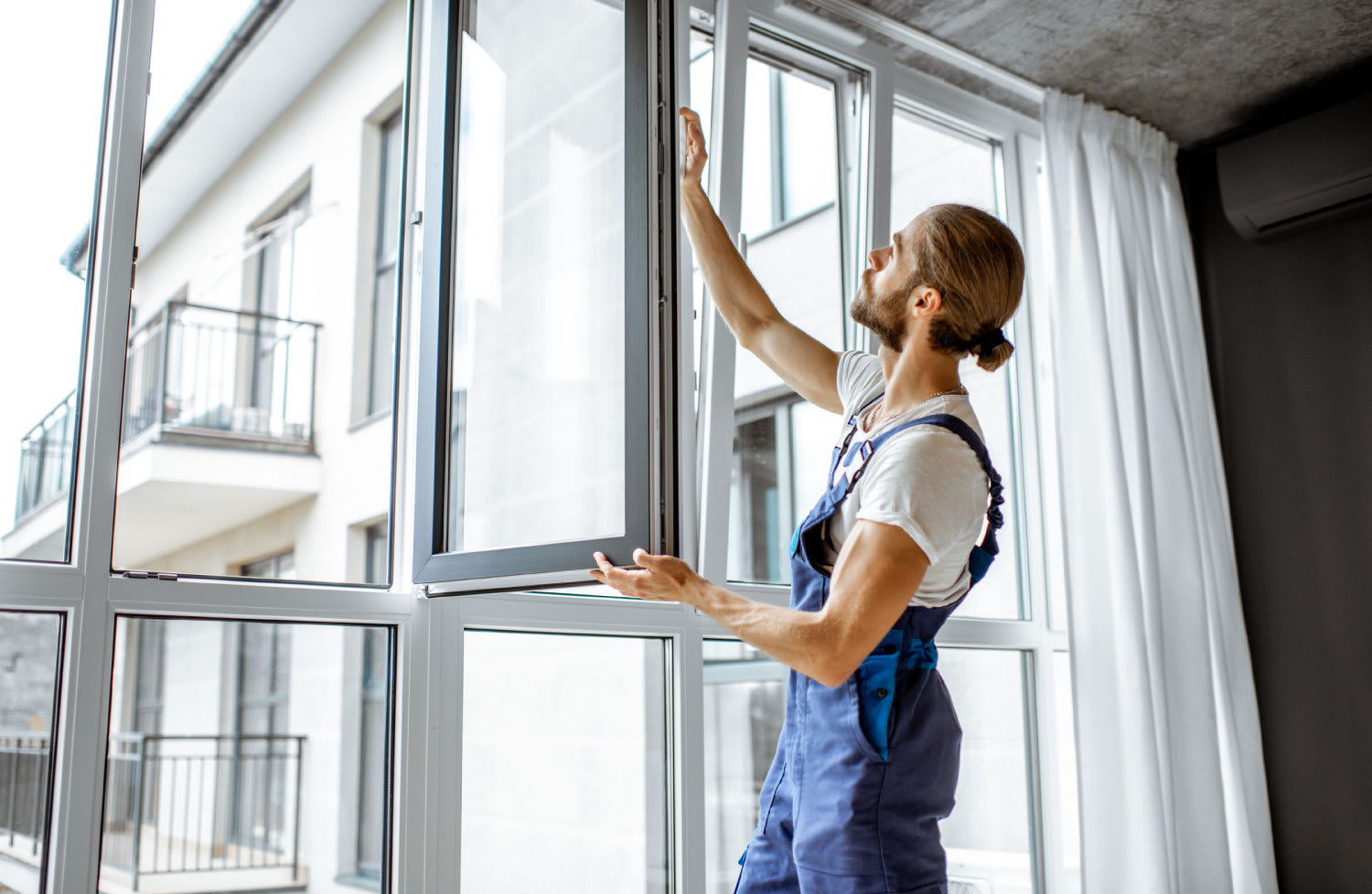 A worker adjusting window frames at home